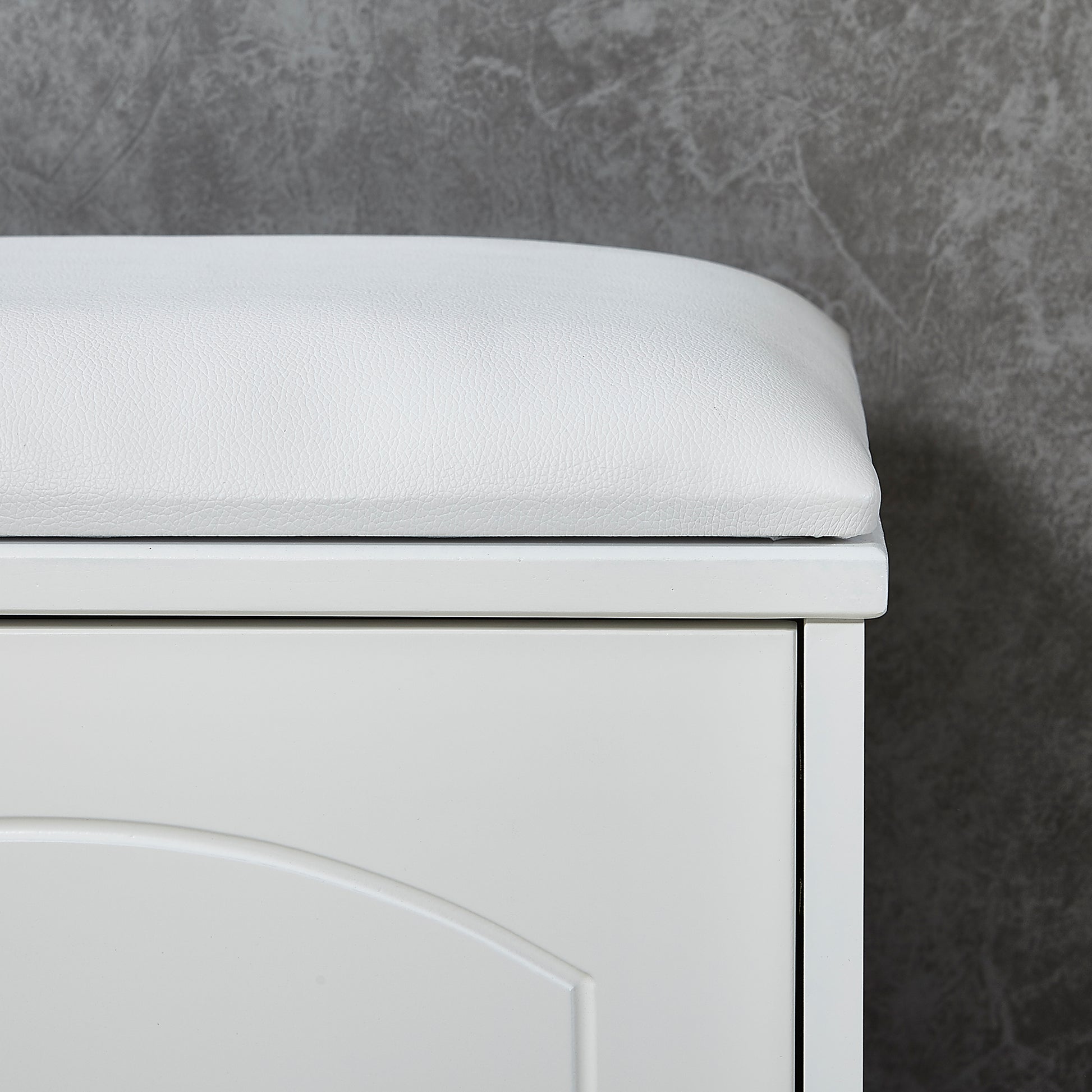 White faux leather padded bench top on a white storage cabinet