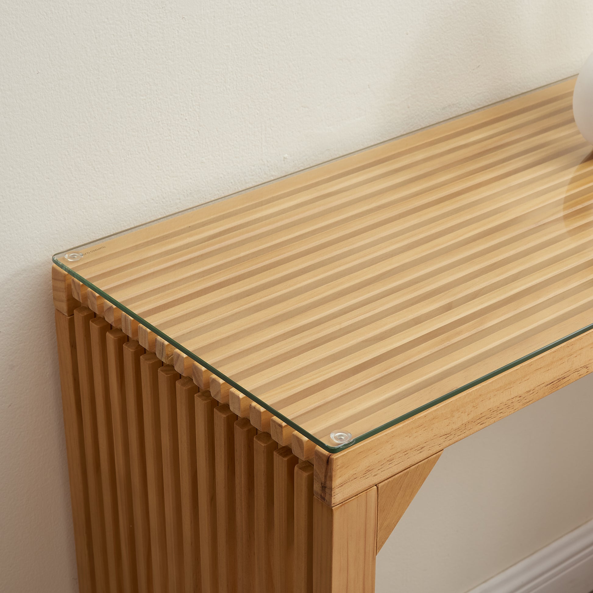 Natural wood console table with glass top and ribbed detailing
