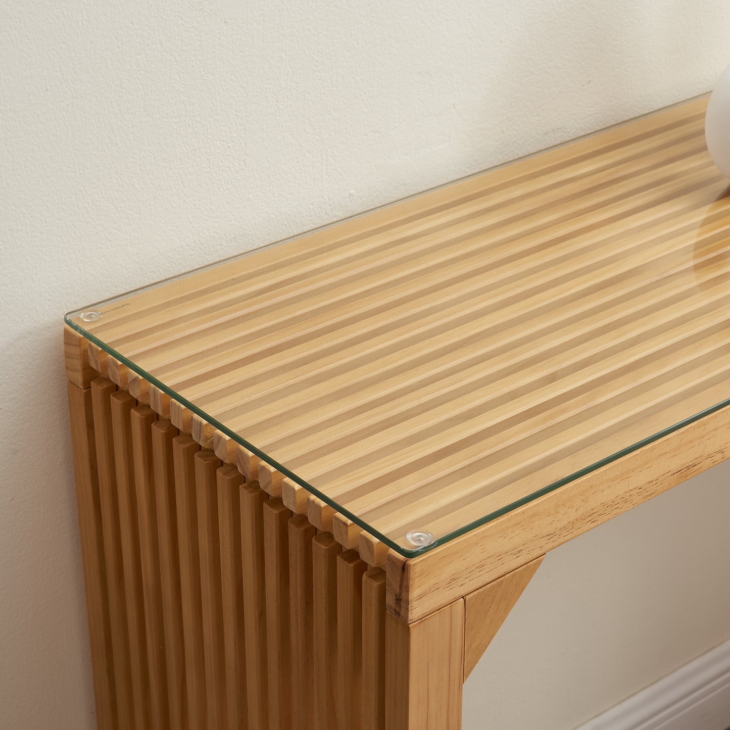 Natural wood console table with ribbed detail and glass top