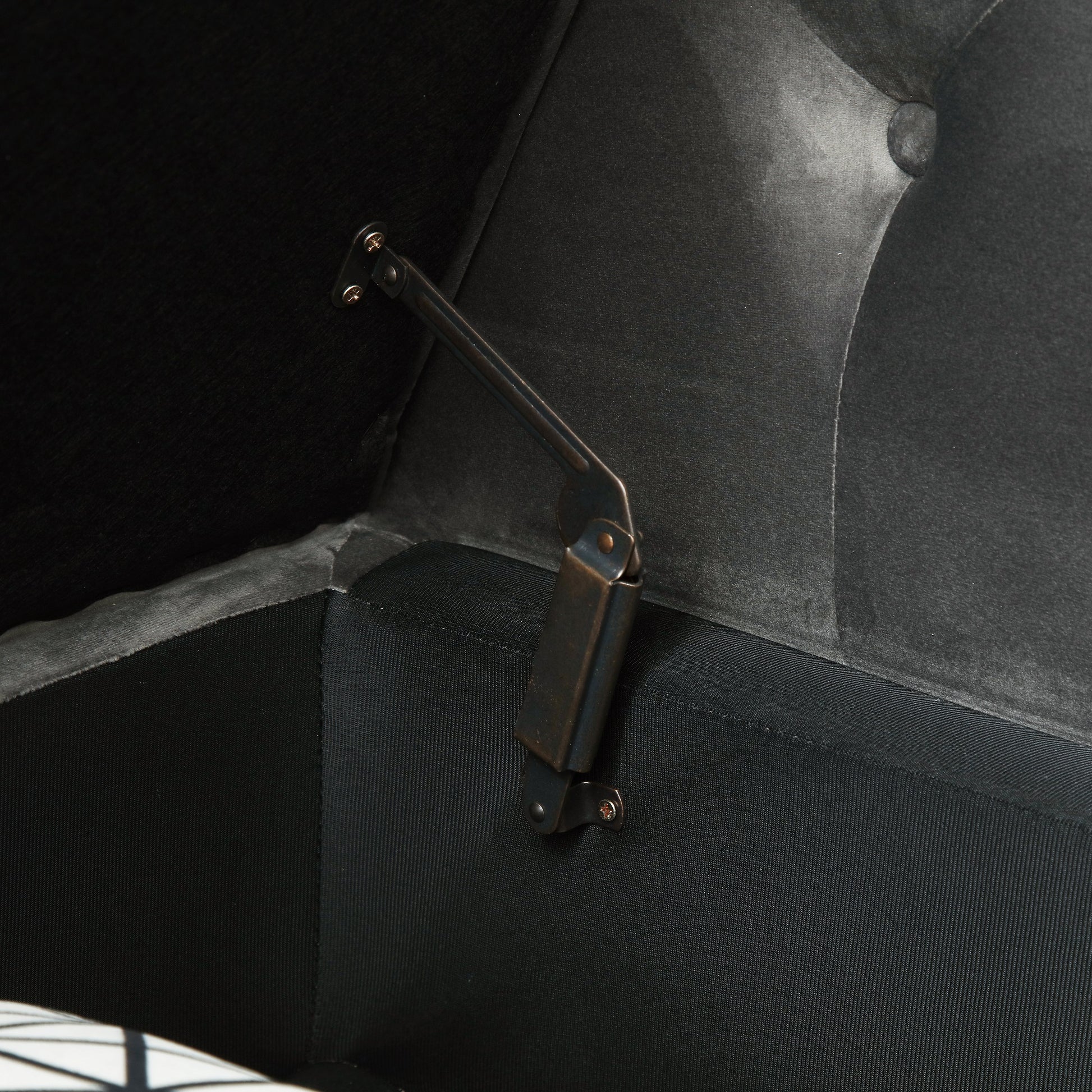 Dark gray velvet storage ottoman interior with bronze hinge