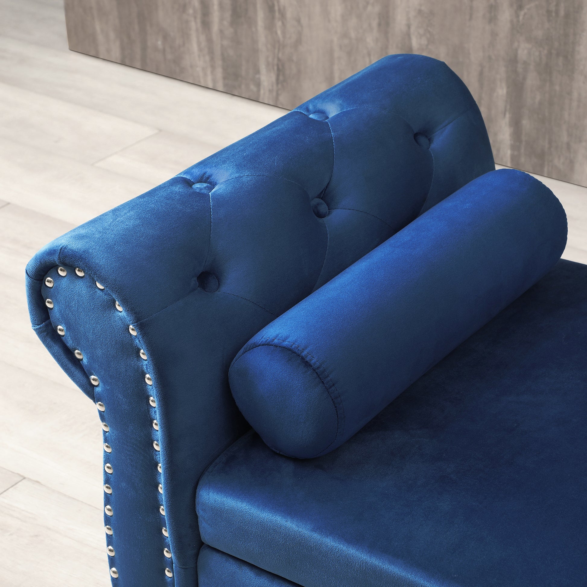 Blue velvet tufted bench with studded arms and bolster pillow