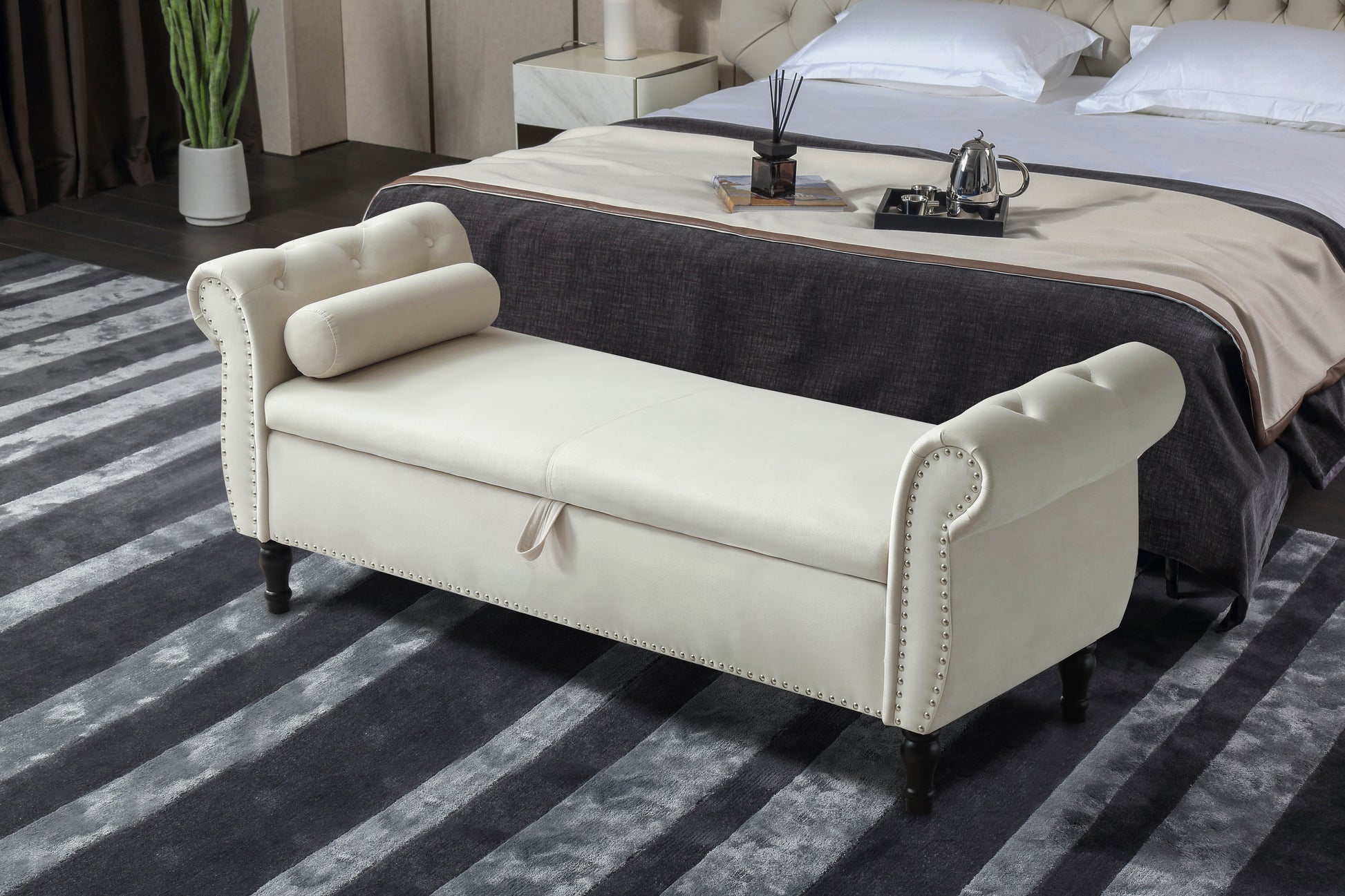 Cream upholstered storage bench with button tufting and silver nailhead trim