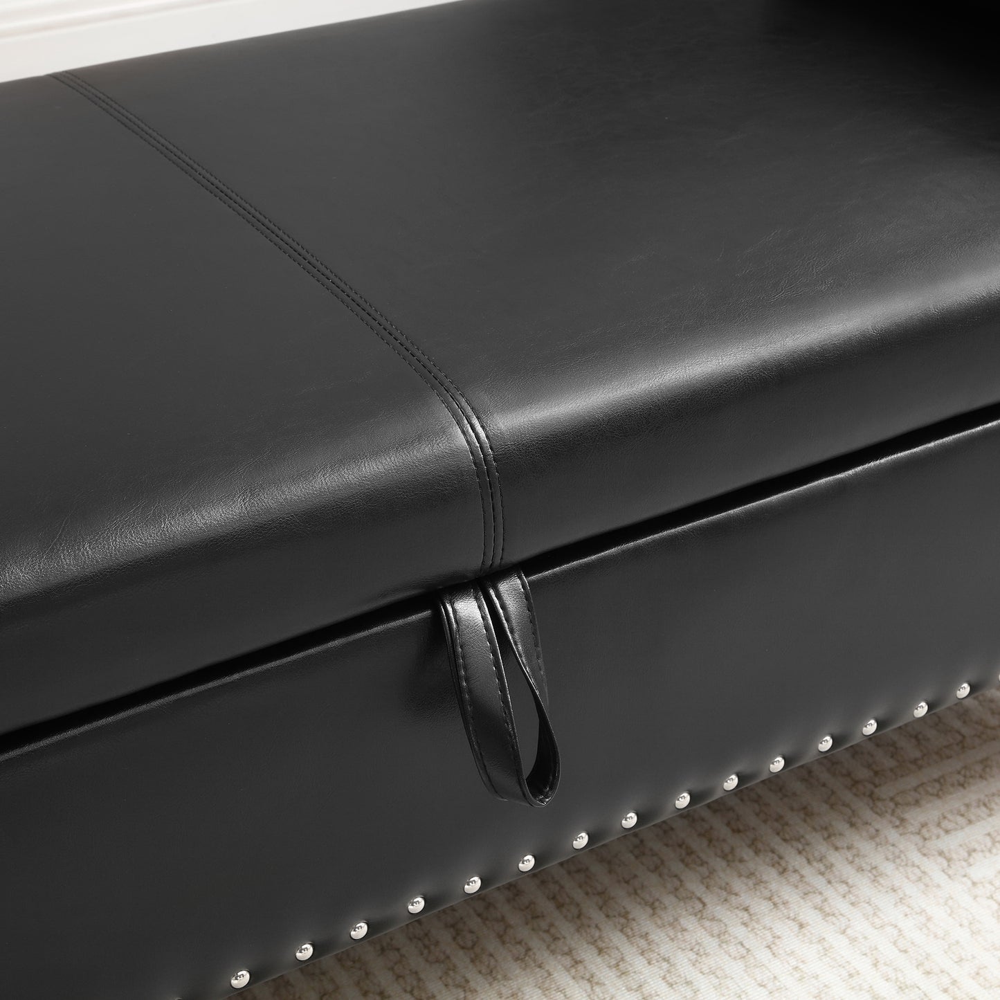 Black faux leather storage ottoman with silver stud detail and lifttop mechanism