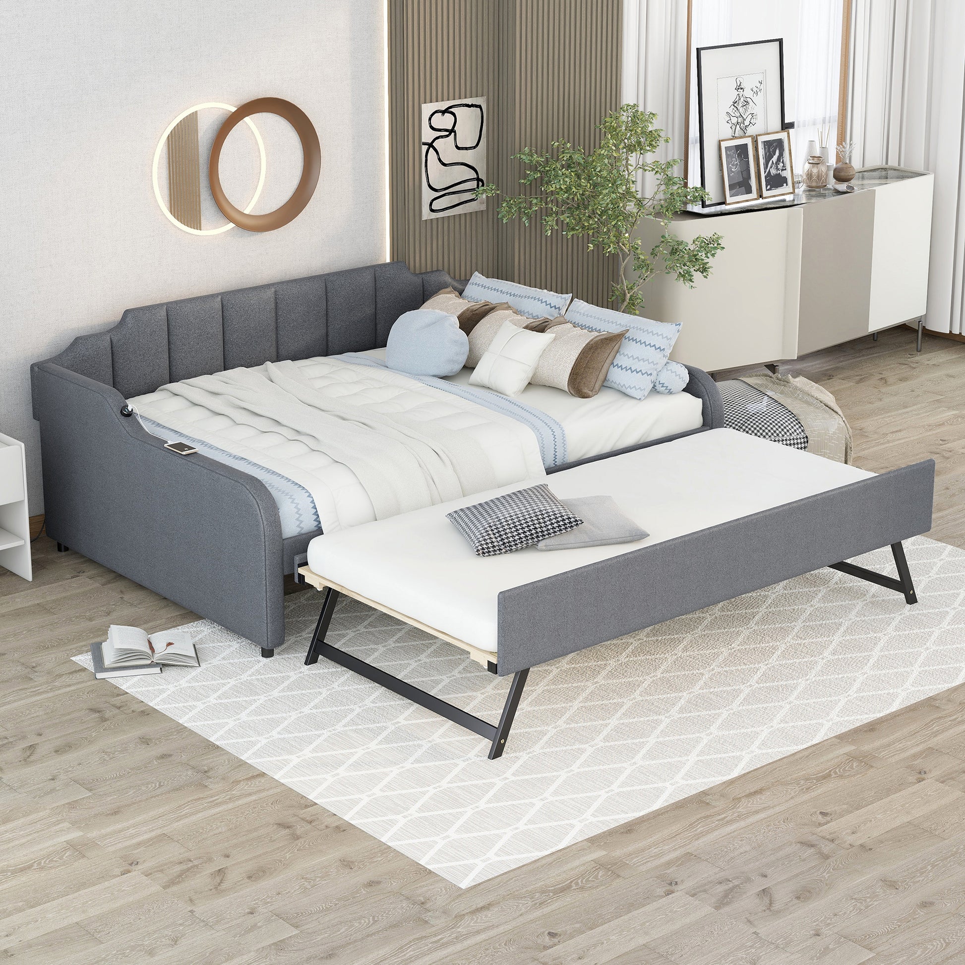 Grey upholstered daybed with trundle pulled out styled with pillows