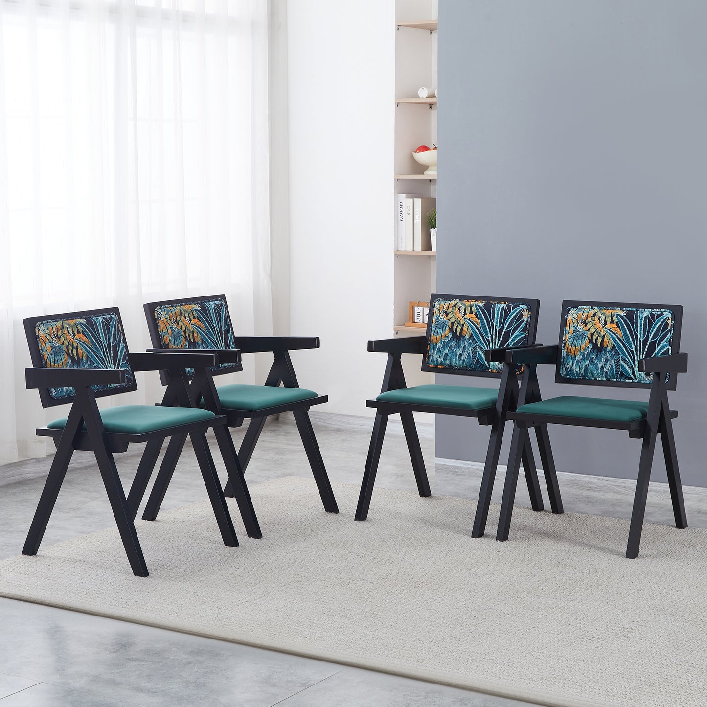 Four black modern chairs with tropical print backrests and emerald green seats