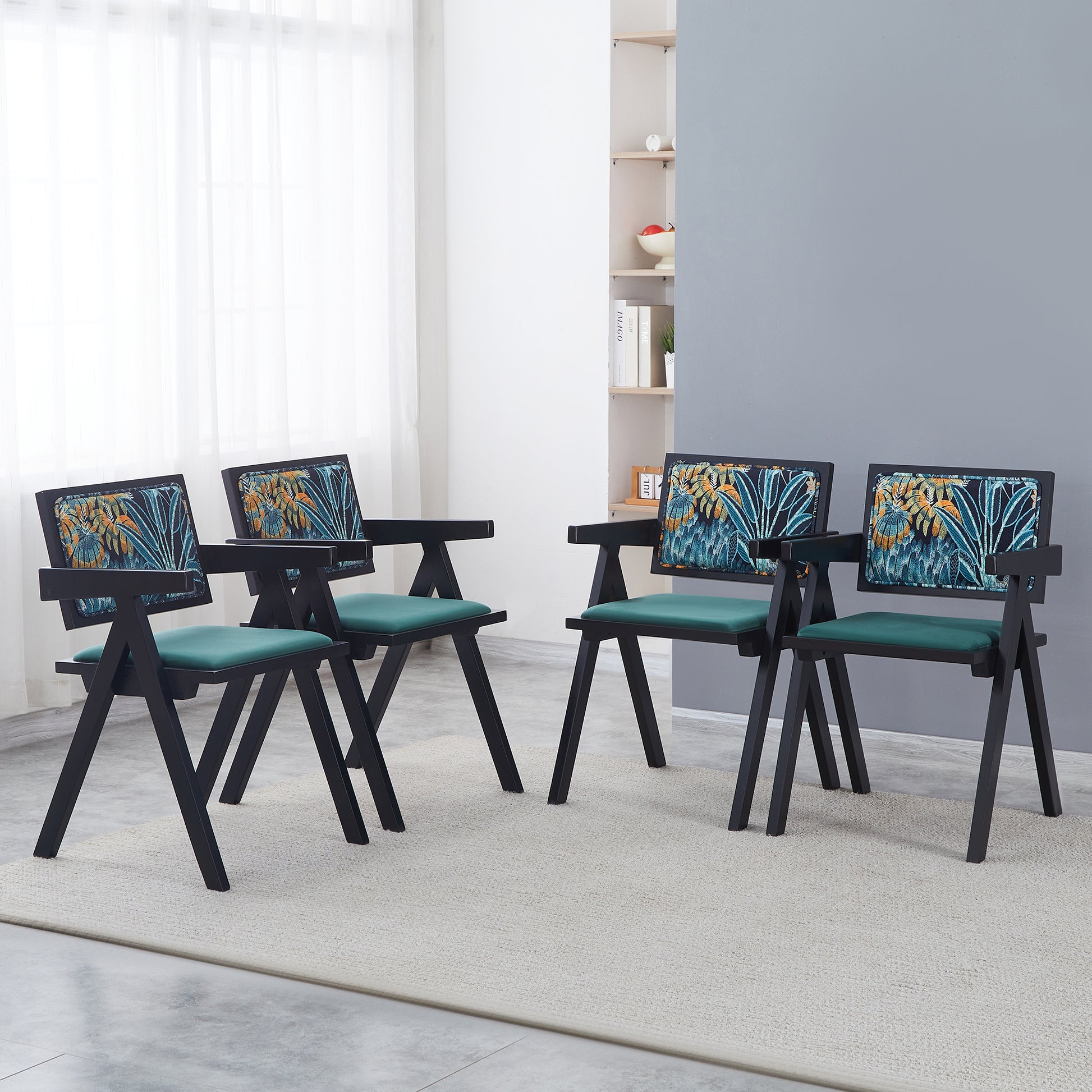 Four black modern chairs with tropical print backrests and emerald green seats
