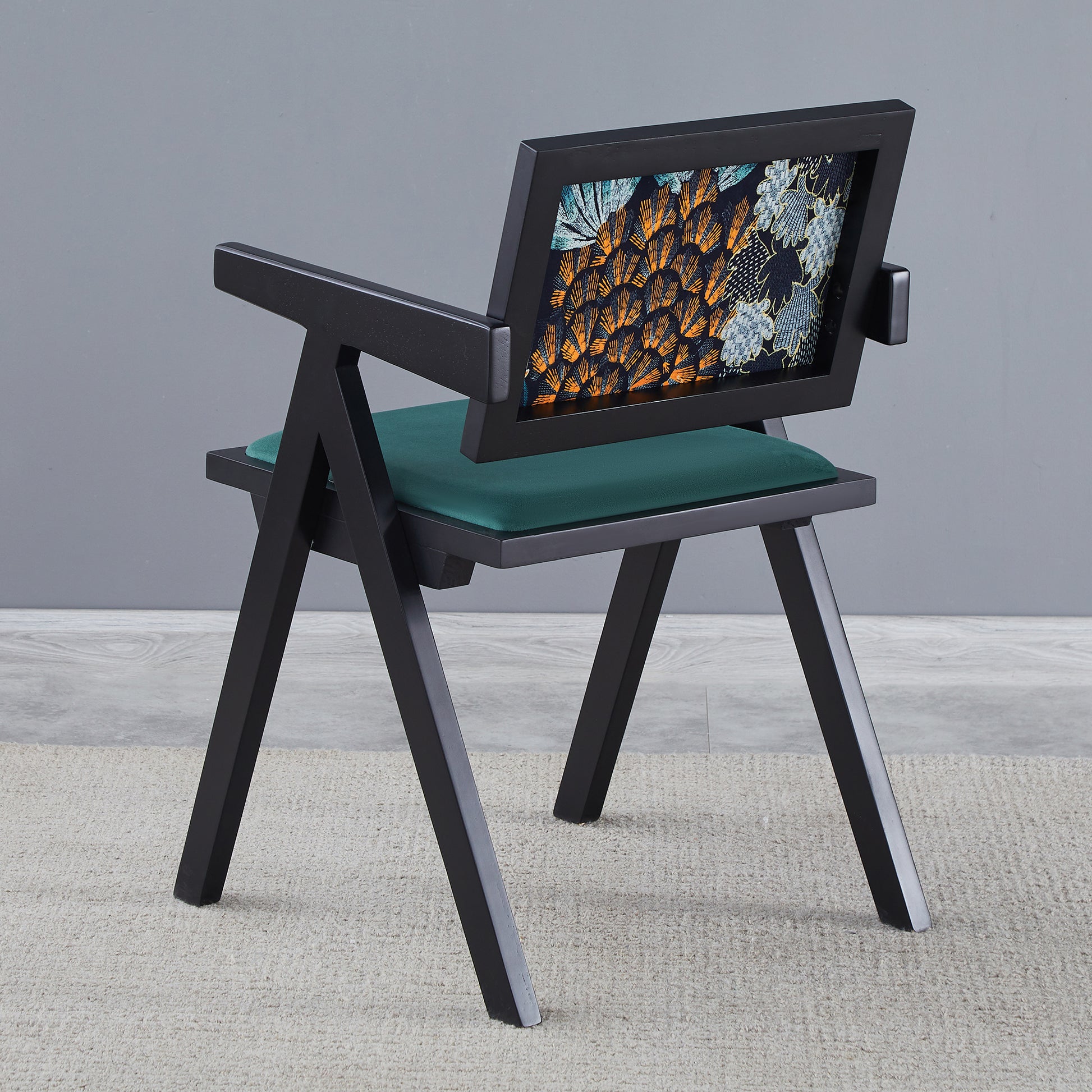 Modern black armchair with dark teal velvet seat and bold geometric pattern backrest
