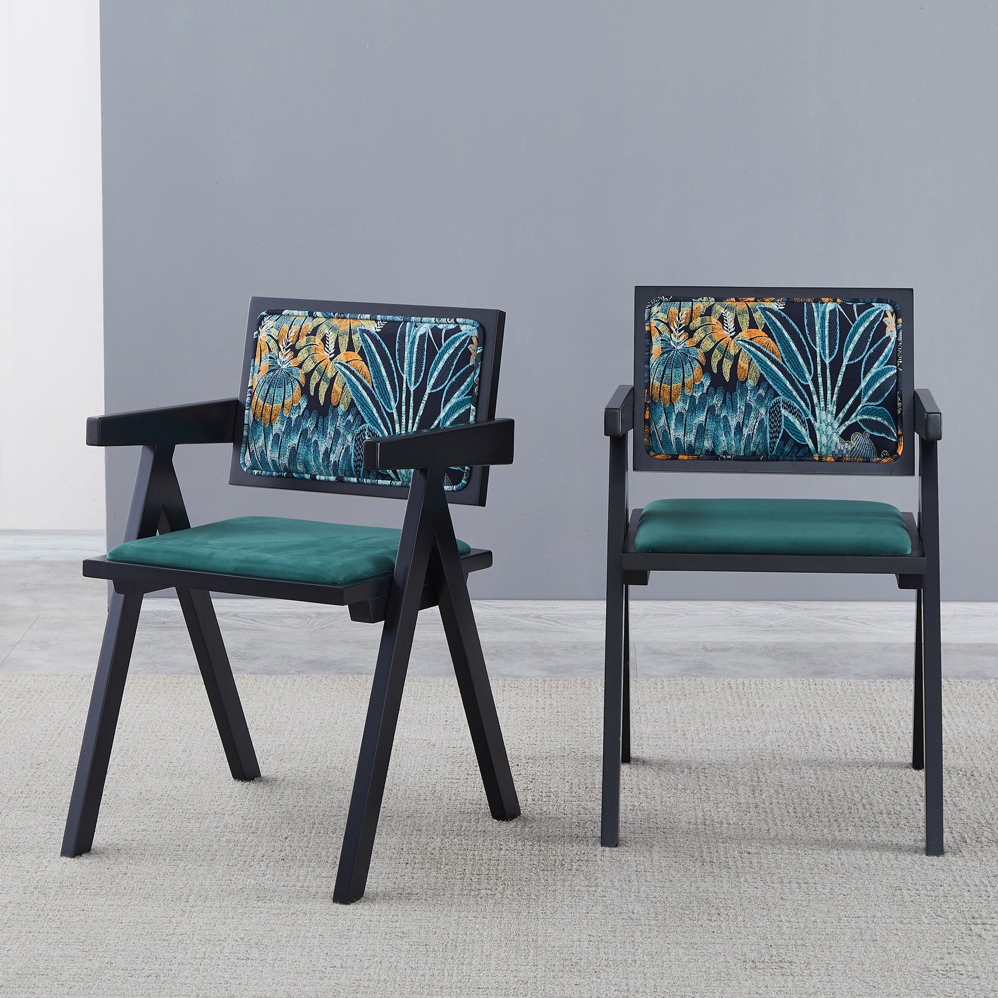 Black wooden accent chair with green seat and tropical leaf patterned backrest