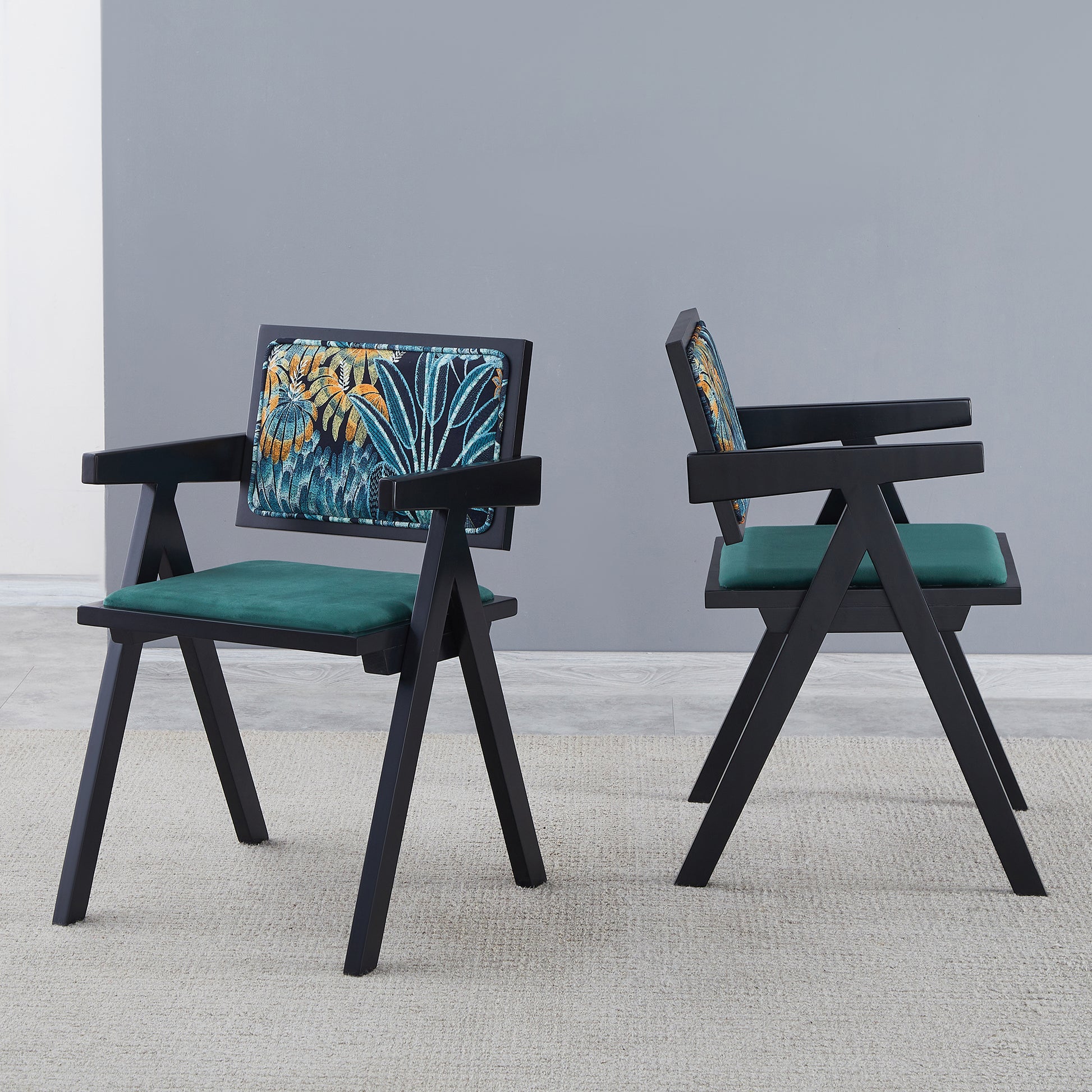 Modern black armchair with green velvet seat and tropical print backrest