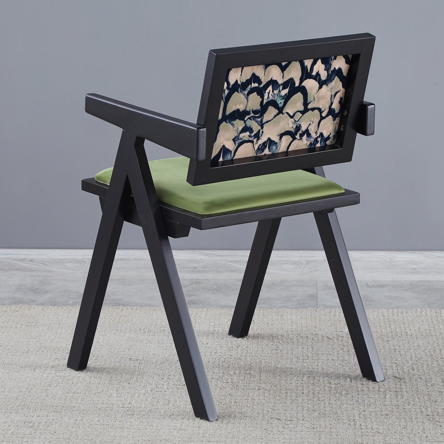 Black modern chair with abstract patterned back and green seat