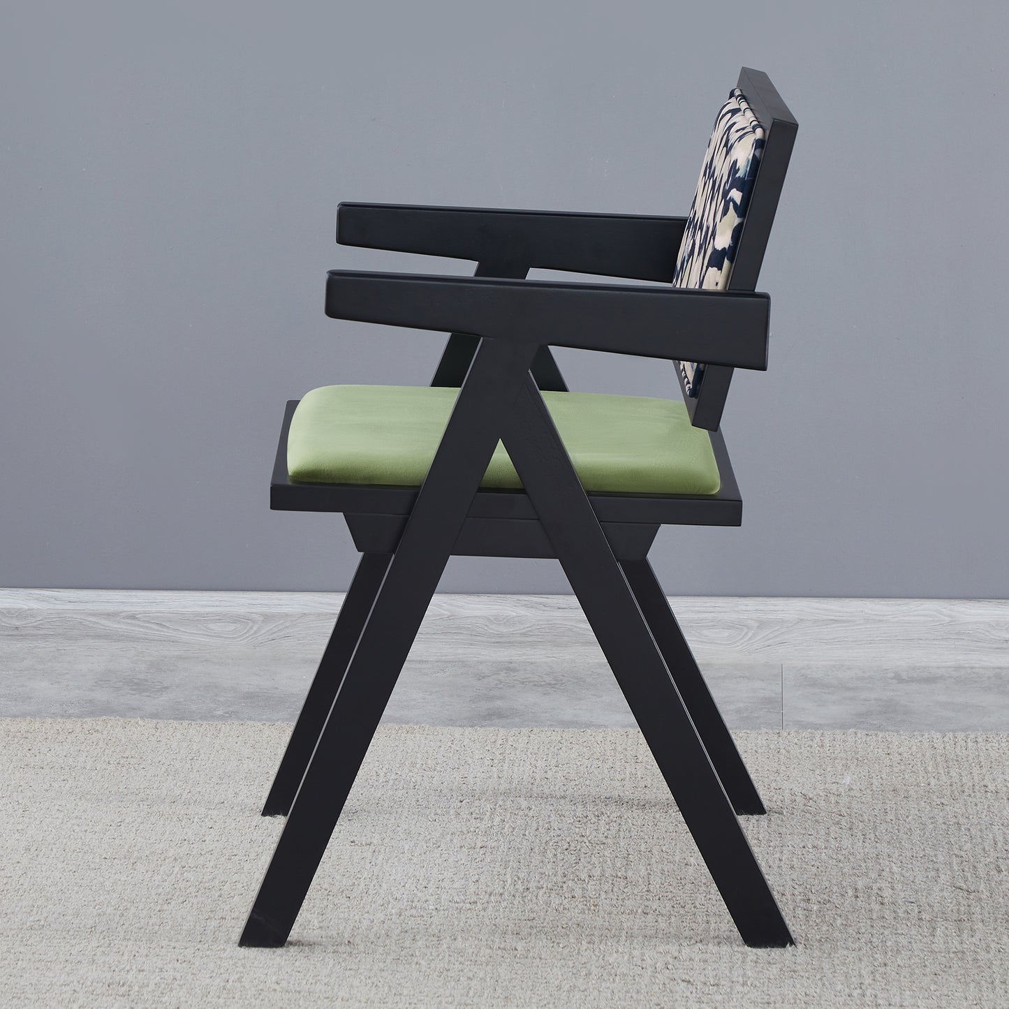 Modern black armchair with green upholstered seat and patterned back