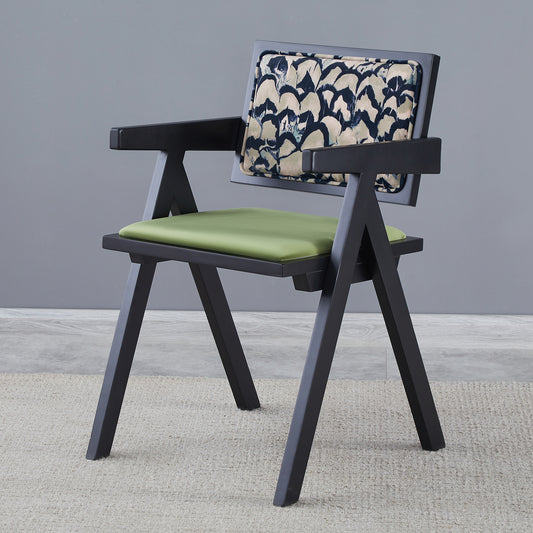 Black armchair with green seat cushion and abstract patterned backrest