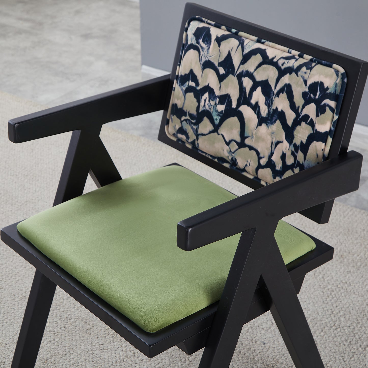 Modern armchair with black frame and green seat cushion