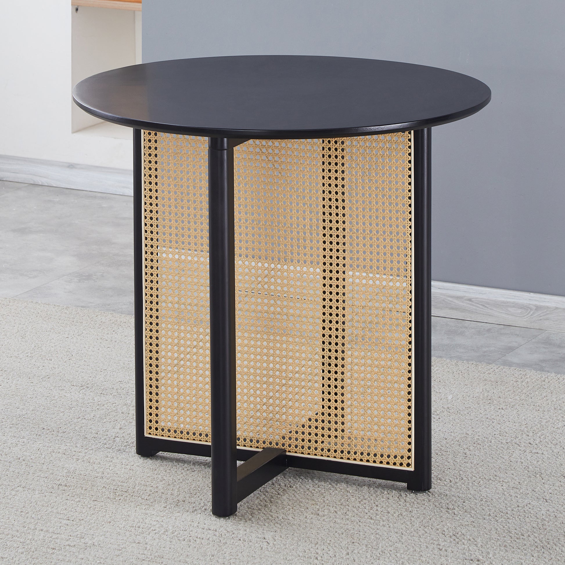 Black round cane accent table with metal legs