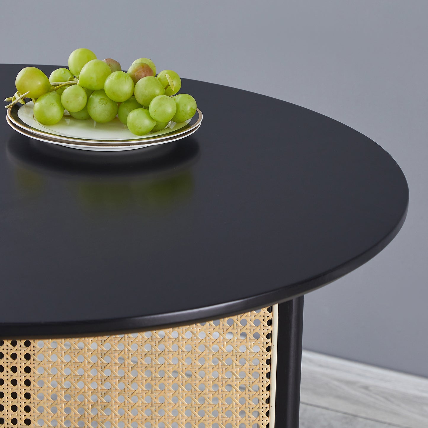 Round black coffee table with woven cane detail