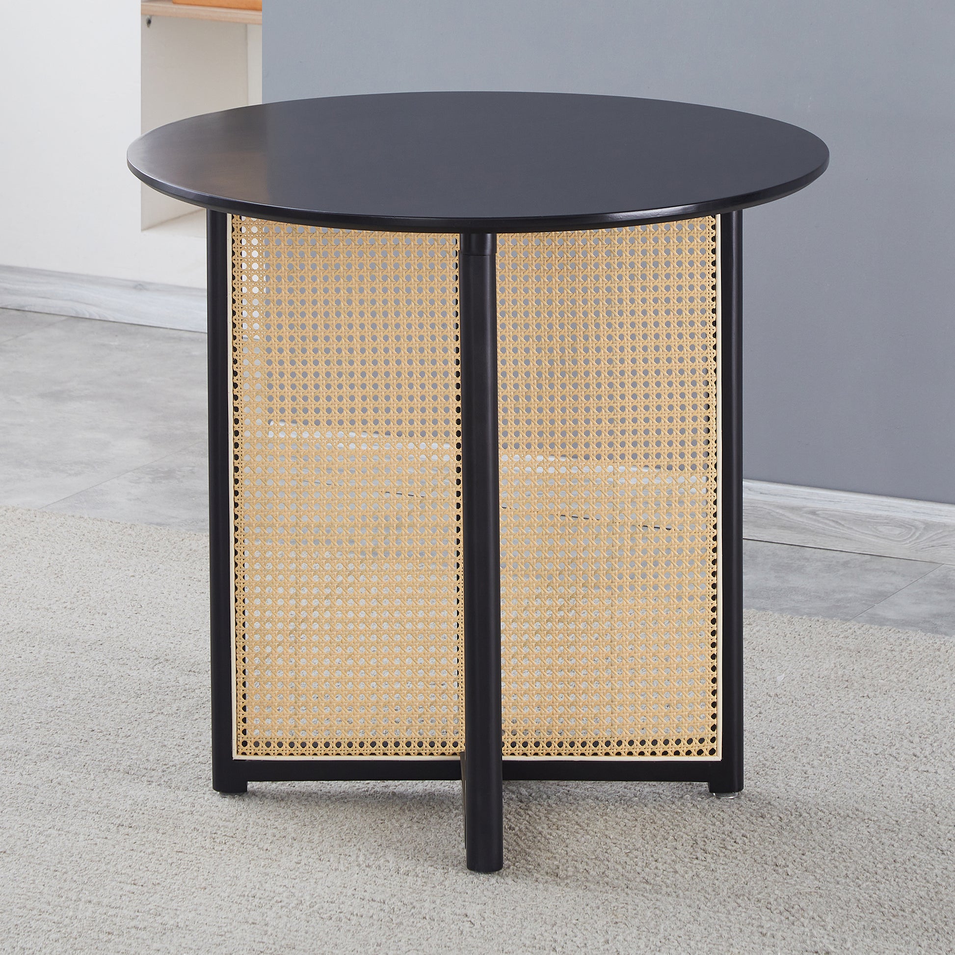 Black round coffee table with woven cane detailing