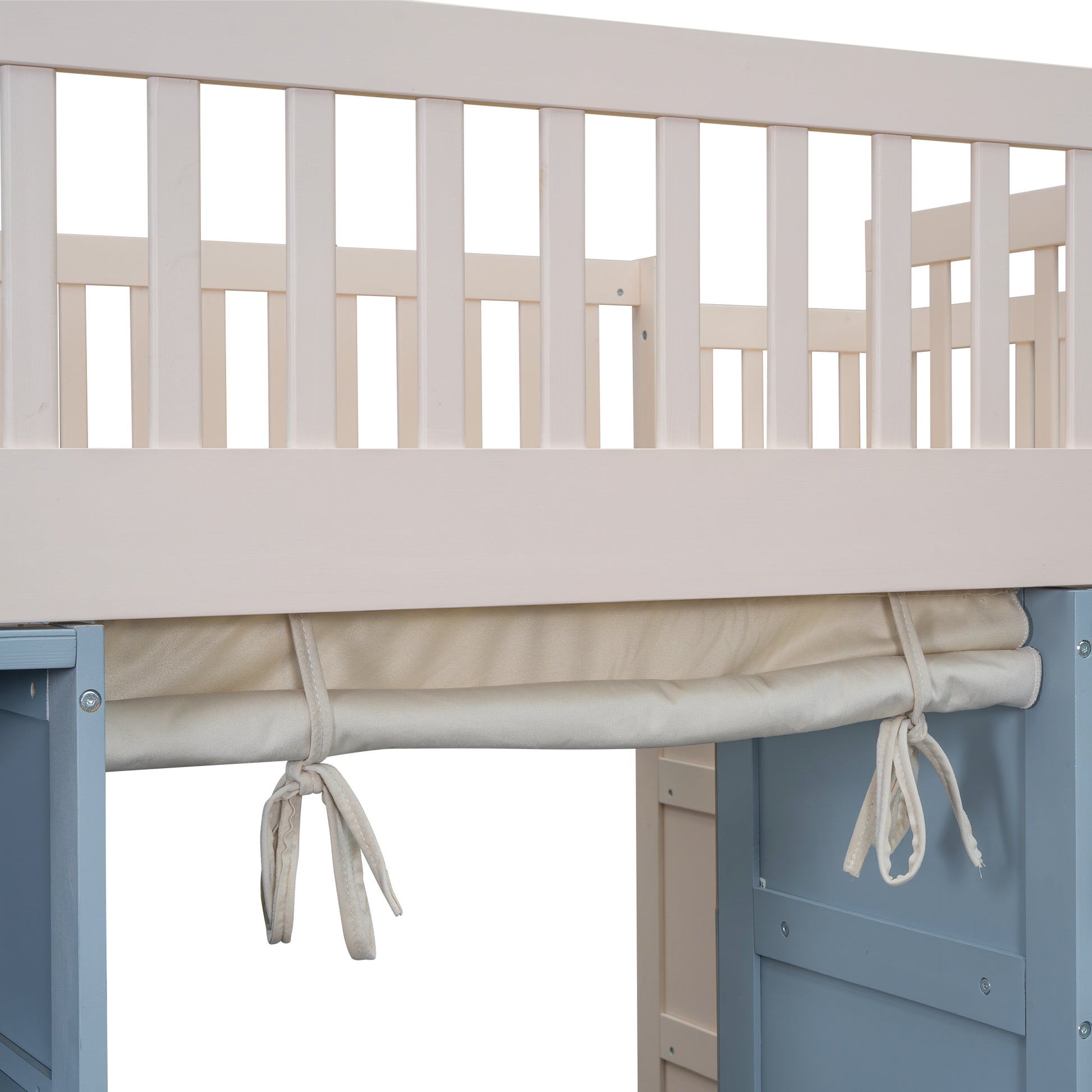 Closeup of beige crib mattress and white wooden safety rail detail