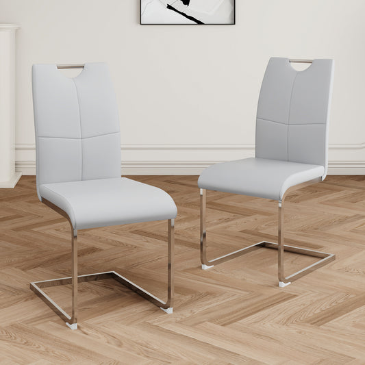 Two light grey faux leather dining chairs with chrome sled legs