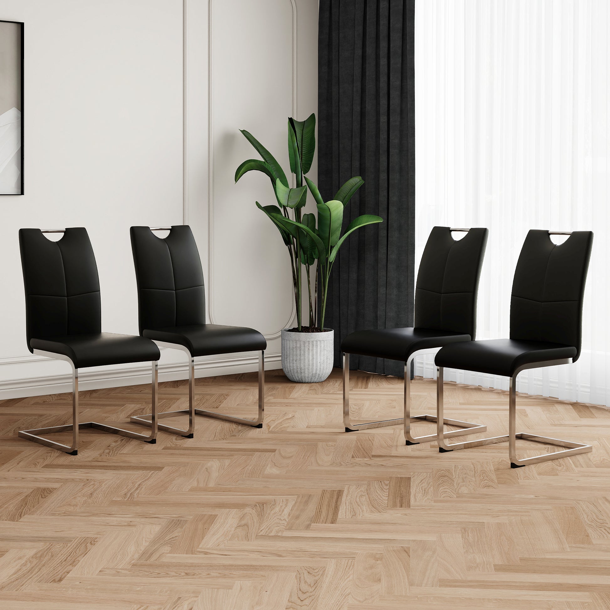 Set of four black faux leather dining chairs with chrome sled legs