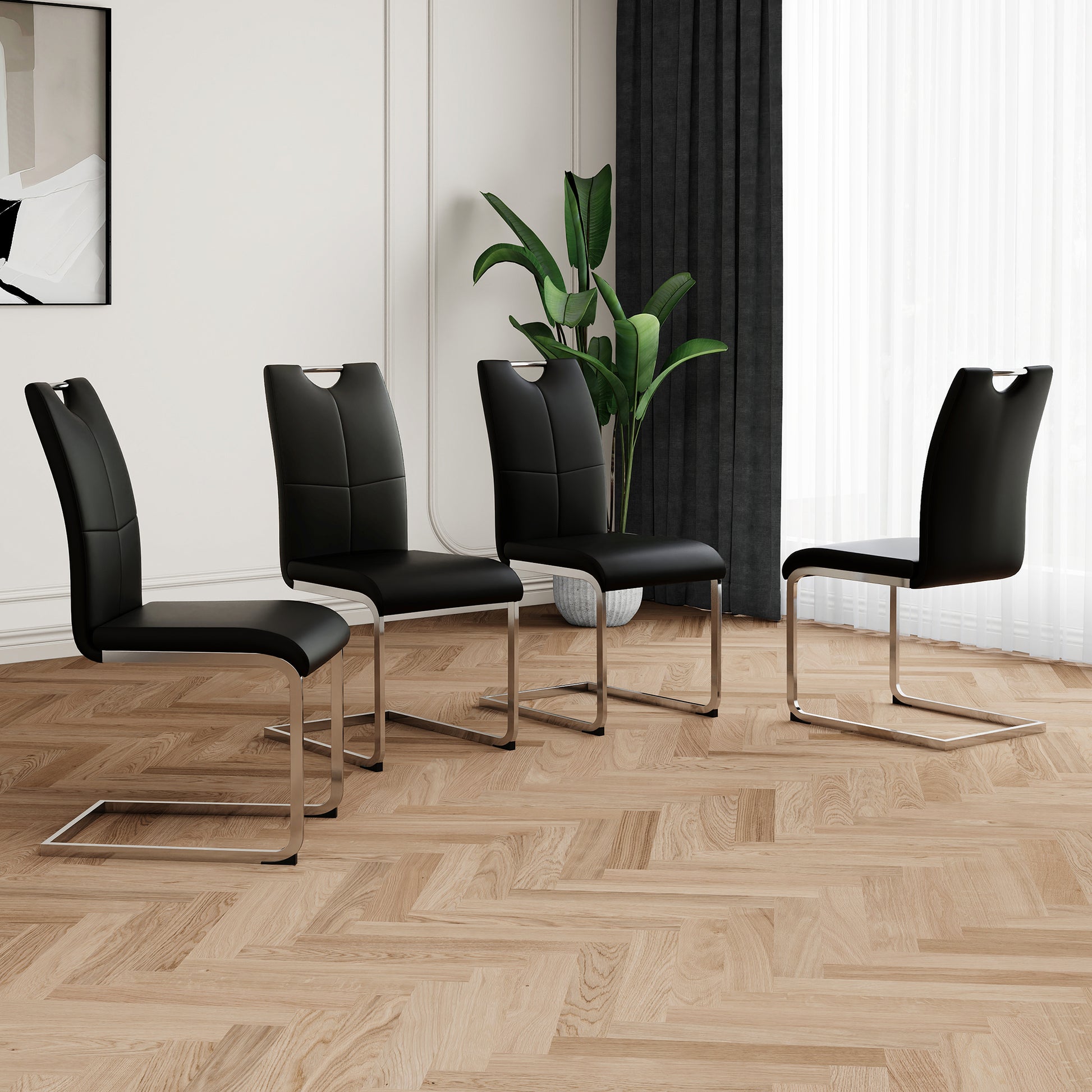 Four black faux leather dining chairs with chrome cantilever bases on a wood floor