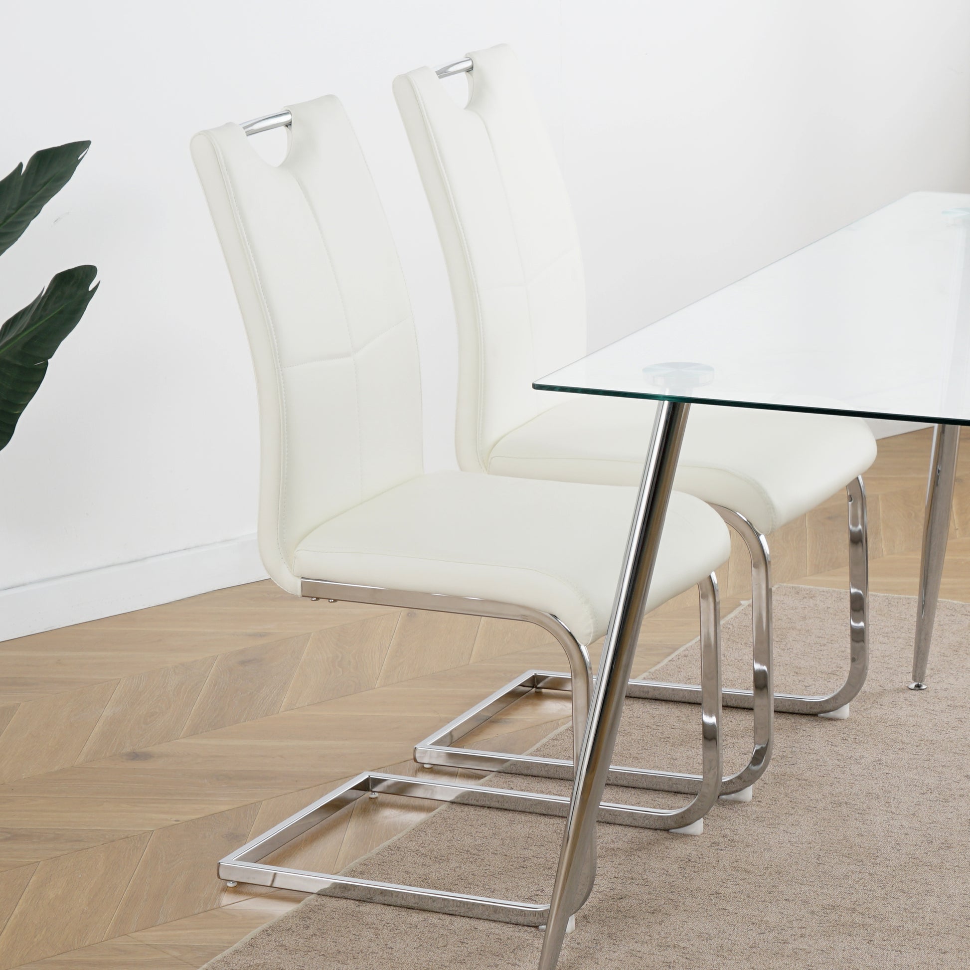 Pair of white faux leather dining chairs with chrome cantilever legs