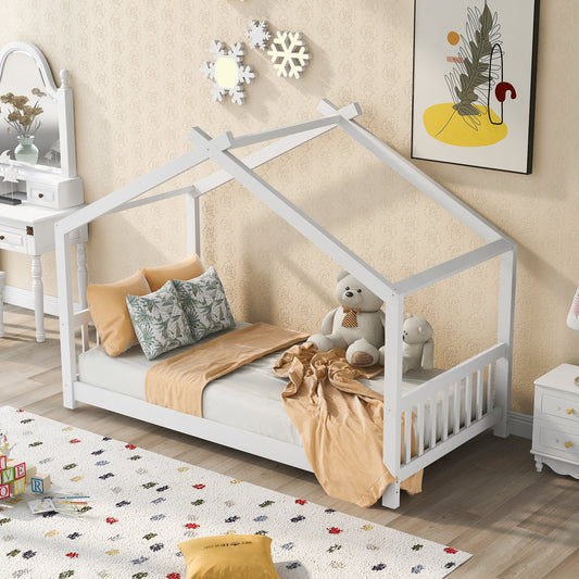 White wooden house bed frame with two plush pillows and an orange throw blanket