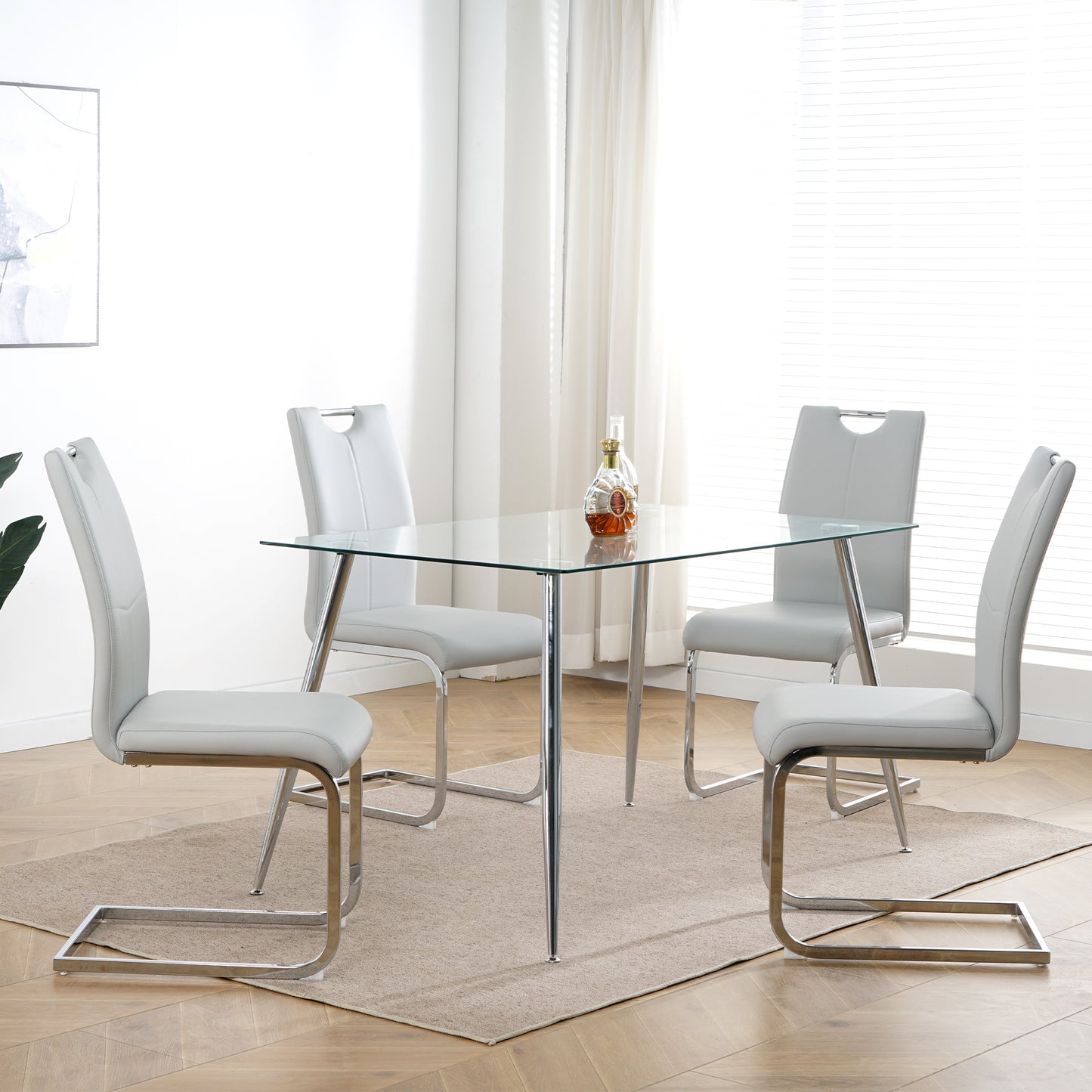 Modern glass dining table with four grey faux leather chairs