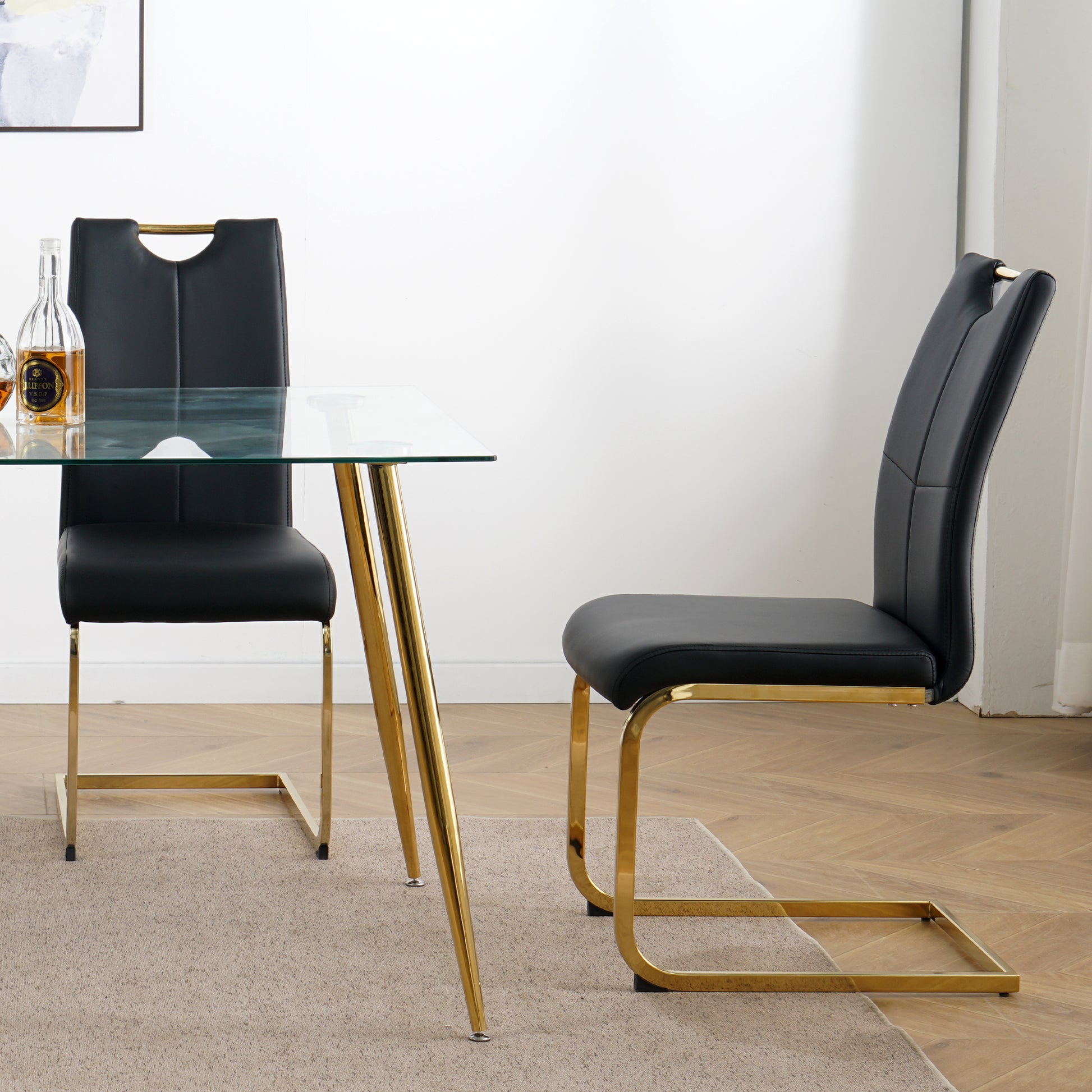 Black faux leather dining chair with gold cantilever base and gold handle accent