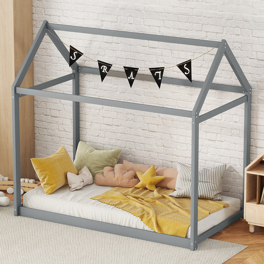 Gray wood toddler bed frame with playful pillows and yellow blanket