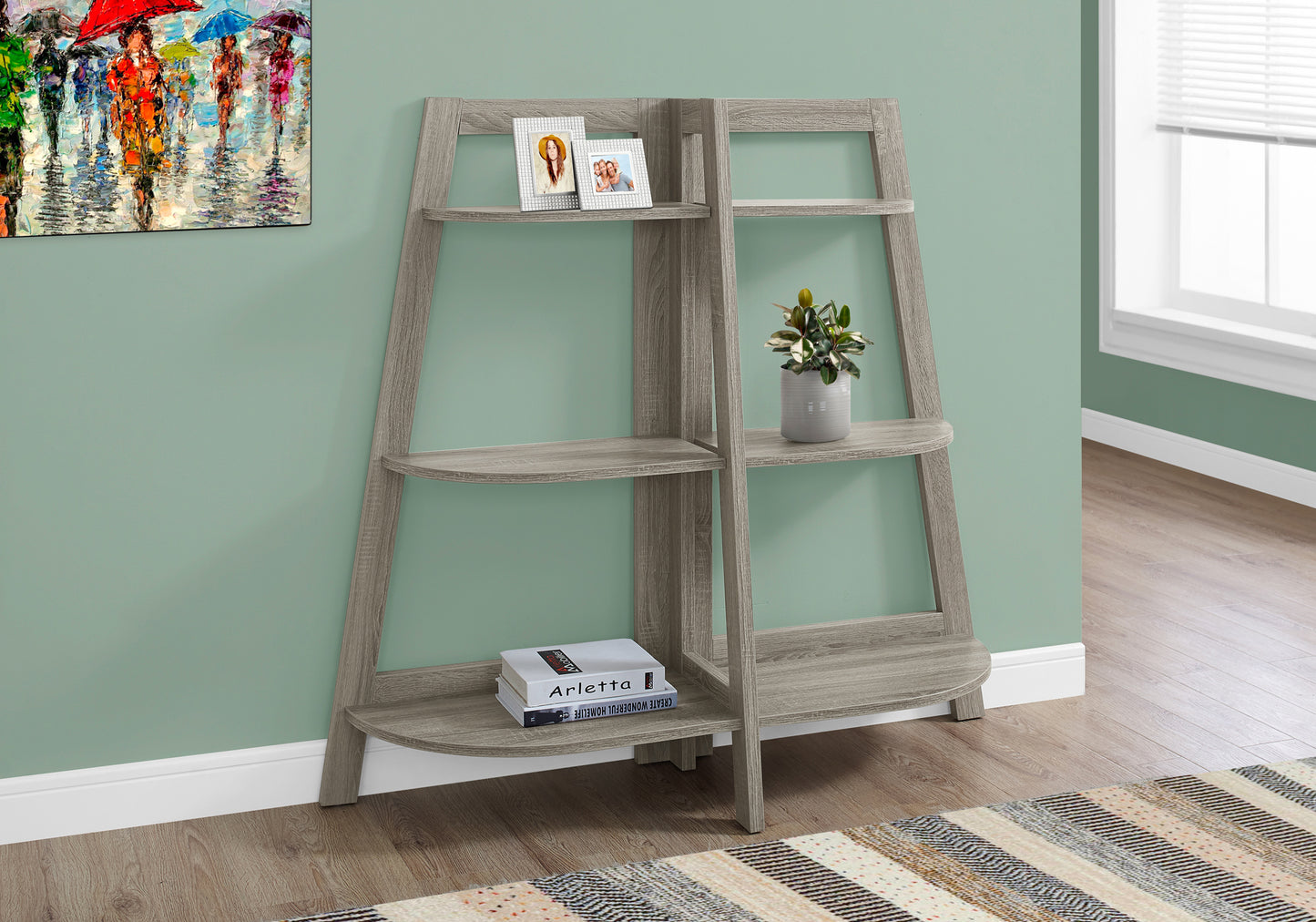 Grey ladder bookshelf with rounded shelves and picture frames