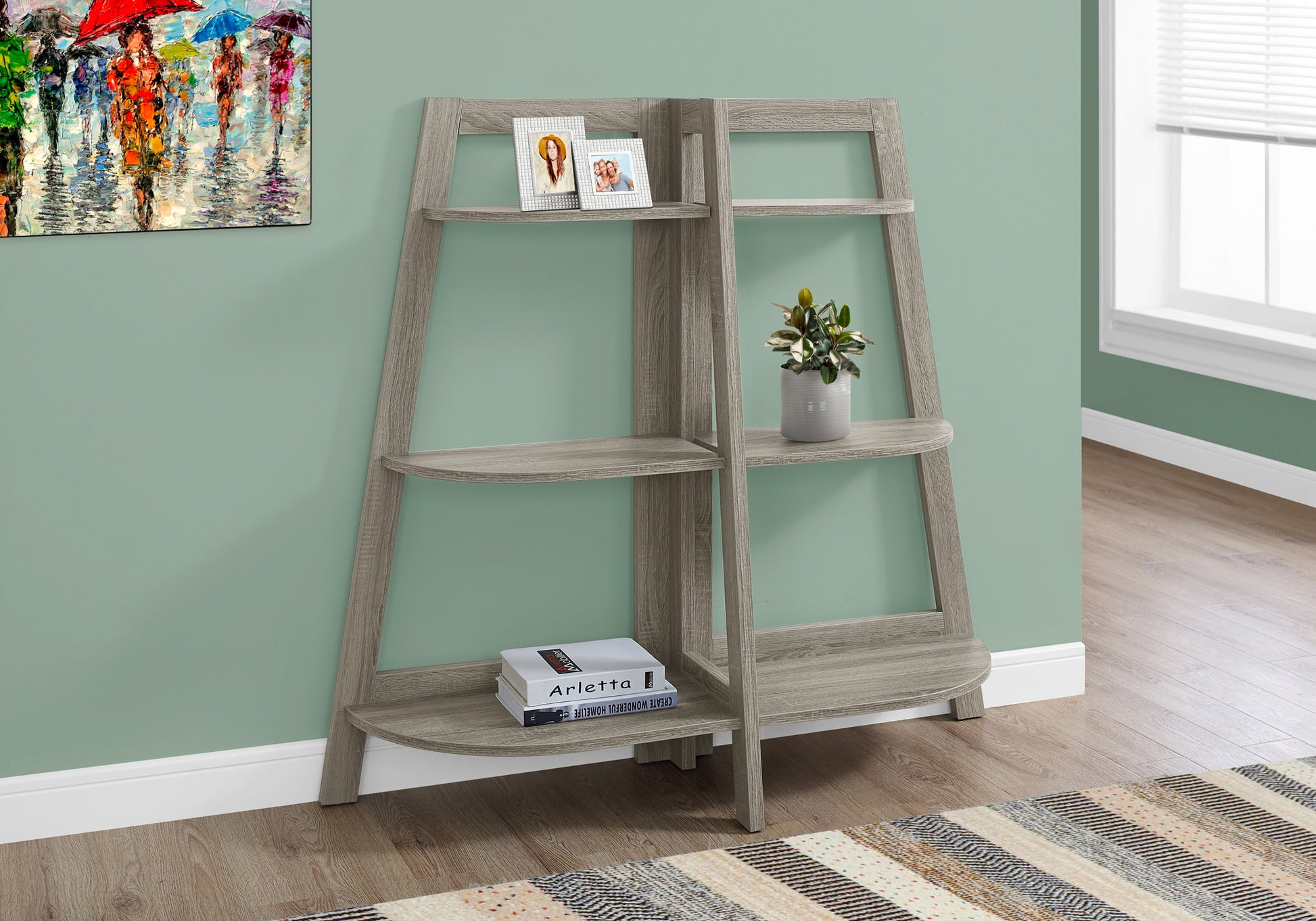 Grey ladder bookshelf with rounded shelves and picture frames
