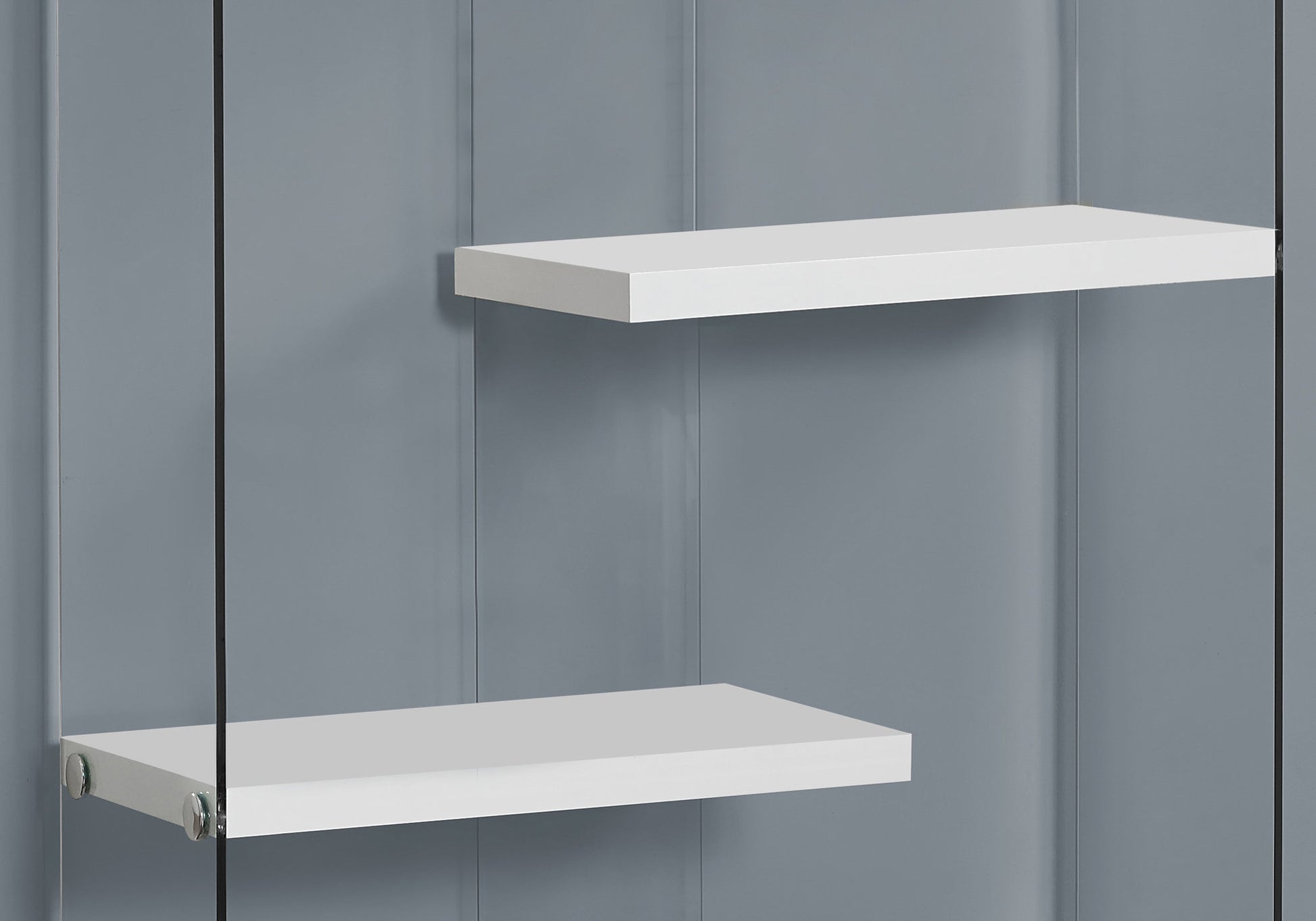 Two minimalist white floating shelves mounted on a grey paneled wall