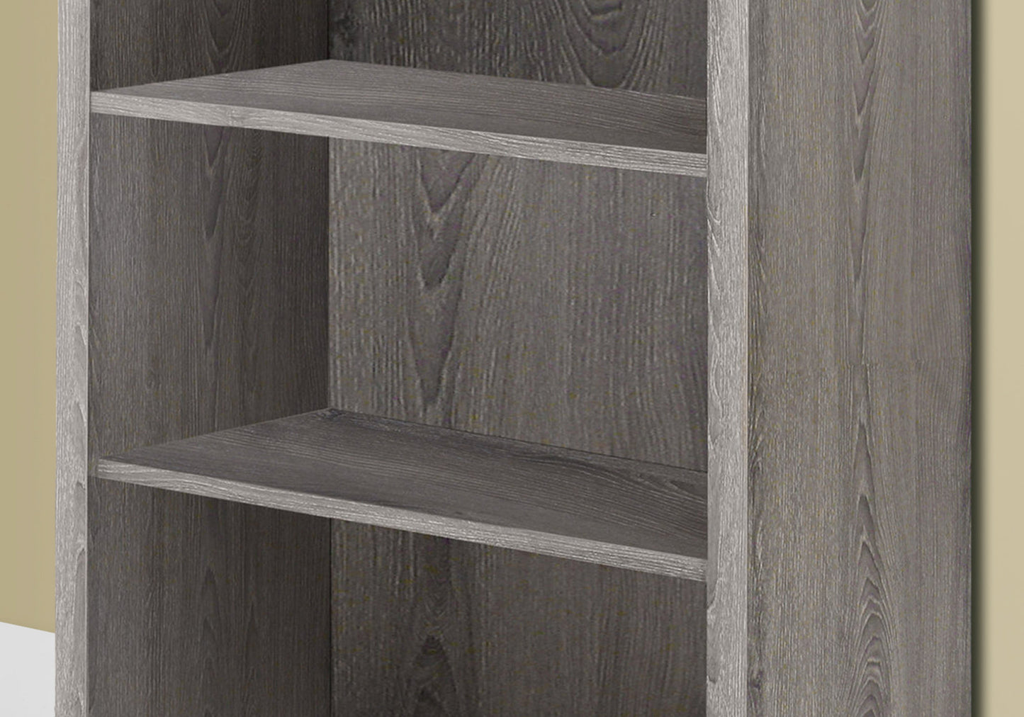 Closeup of a grey wood grain bookshelf with three shelves