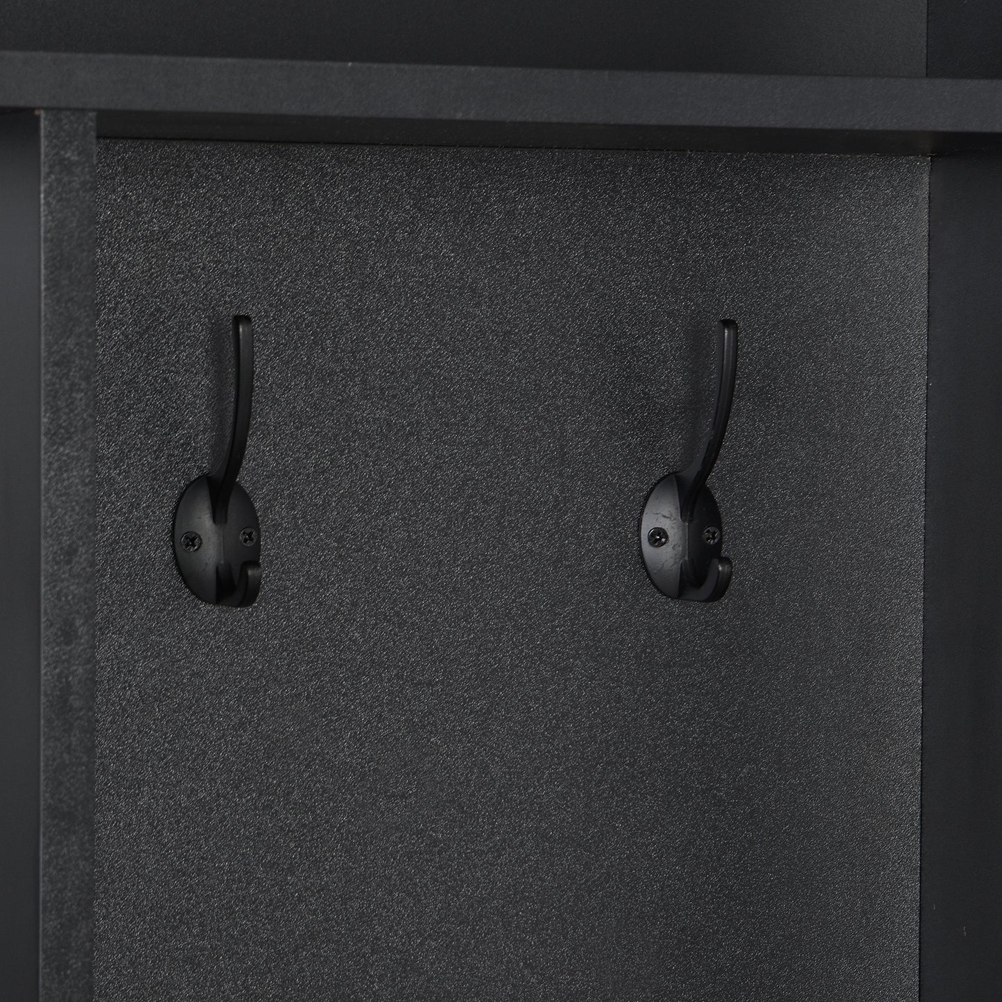 Two black metal coat hooks mounted on a textured black panel