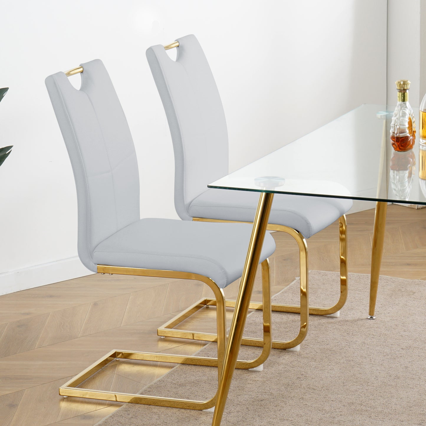 Light gray upholstered dining chairs with gold sled legs