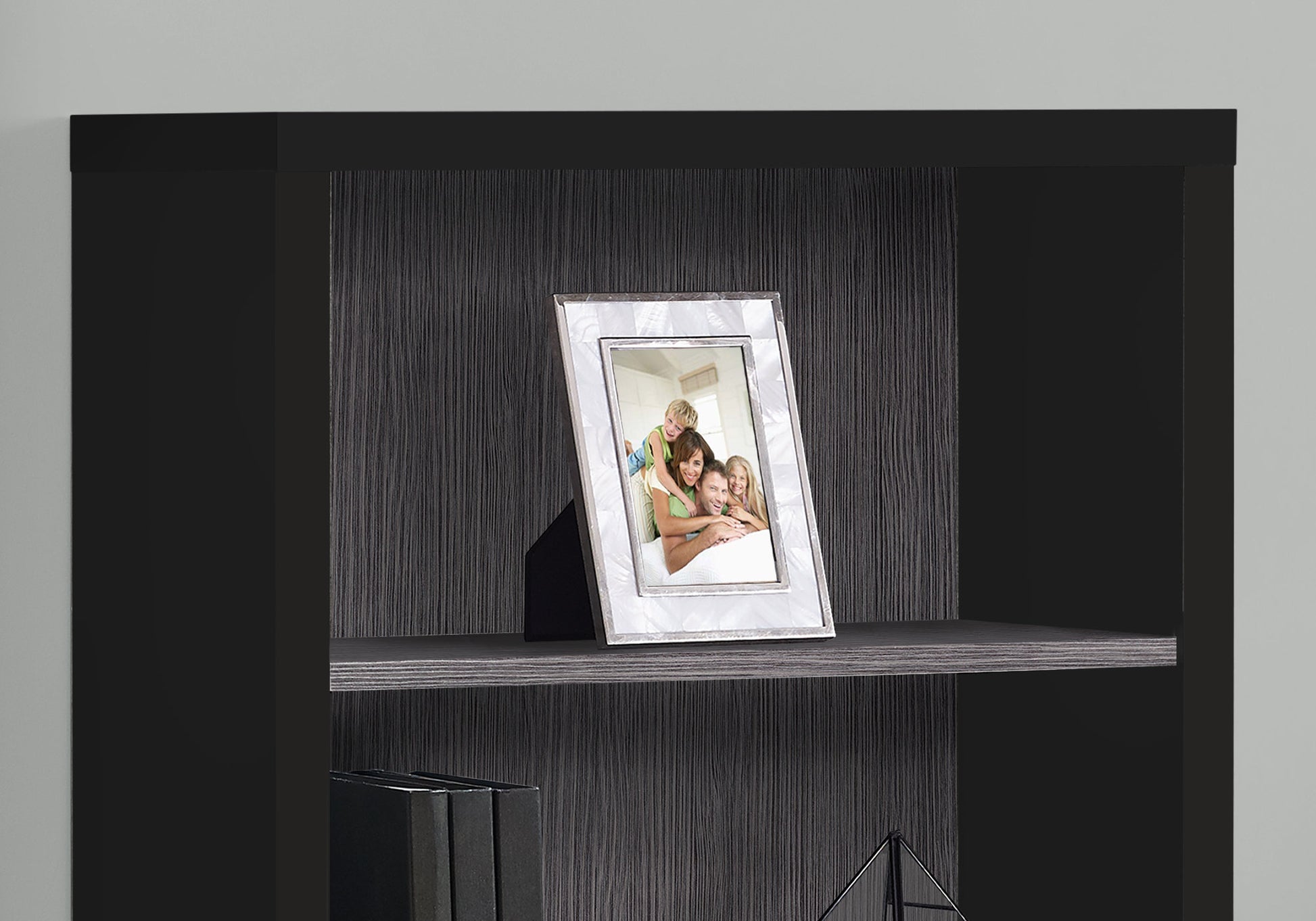 Silver ornate picture frame holding a family photo on a shelf