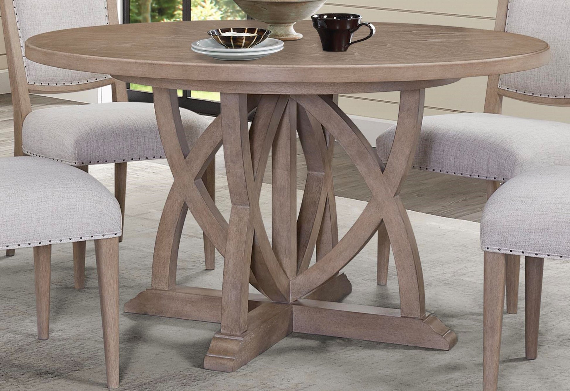Rustic round oak dining table with intricate wooden pedestal base