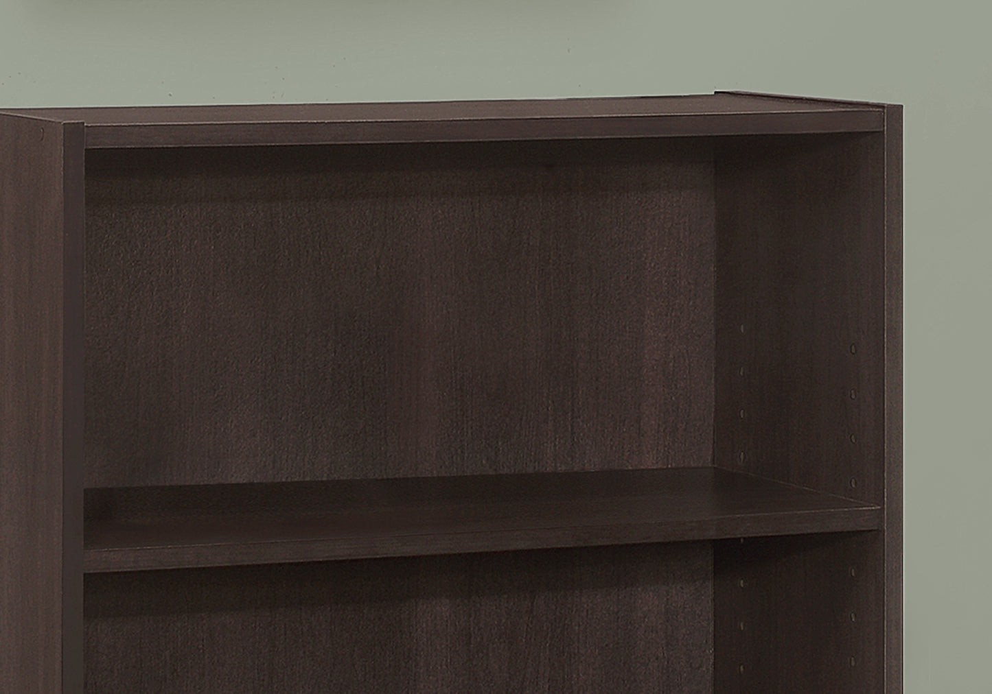 Dark brown particleboard bookshelf with two visible shelves
