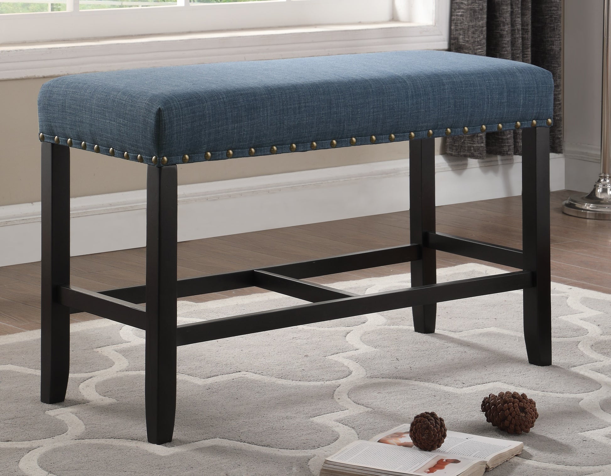 Blue upholstered dining bench with nailhead trim and dark wood legs