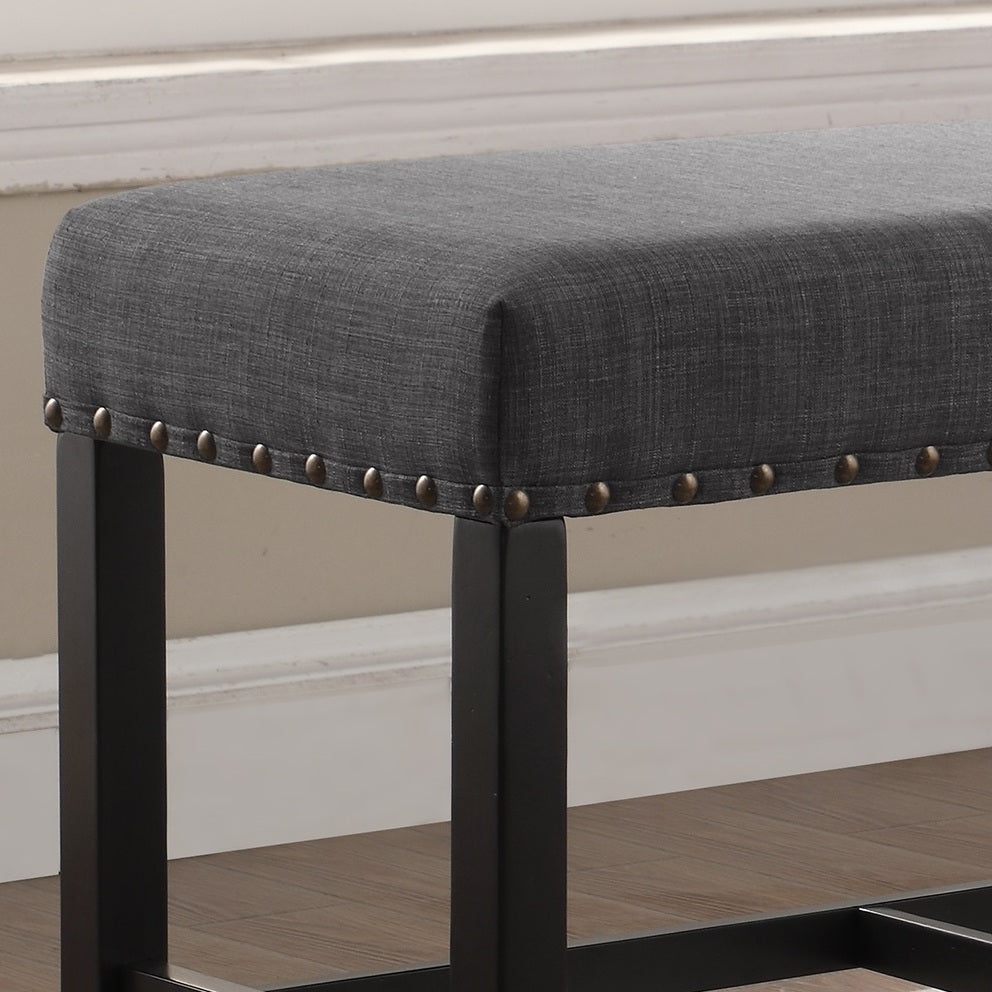 Dark gray upholstered bench with brass nailhead trim and black metal legs