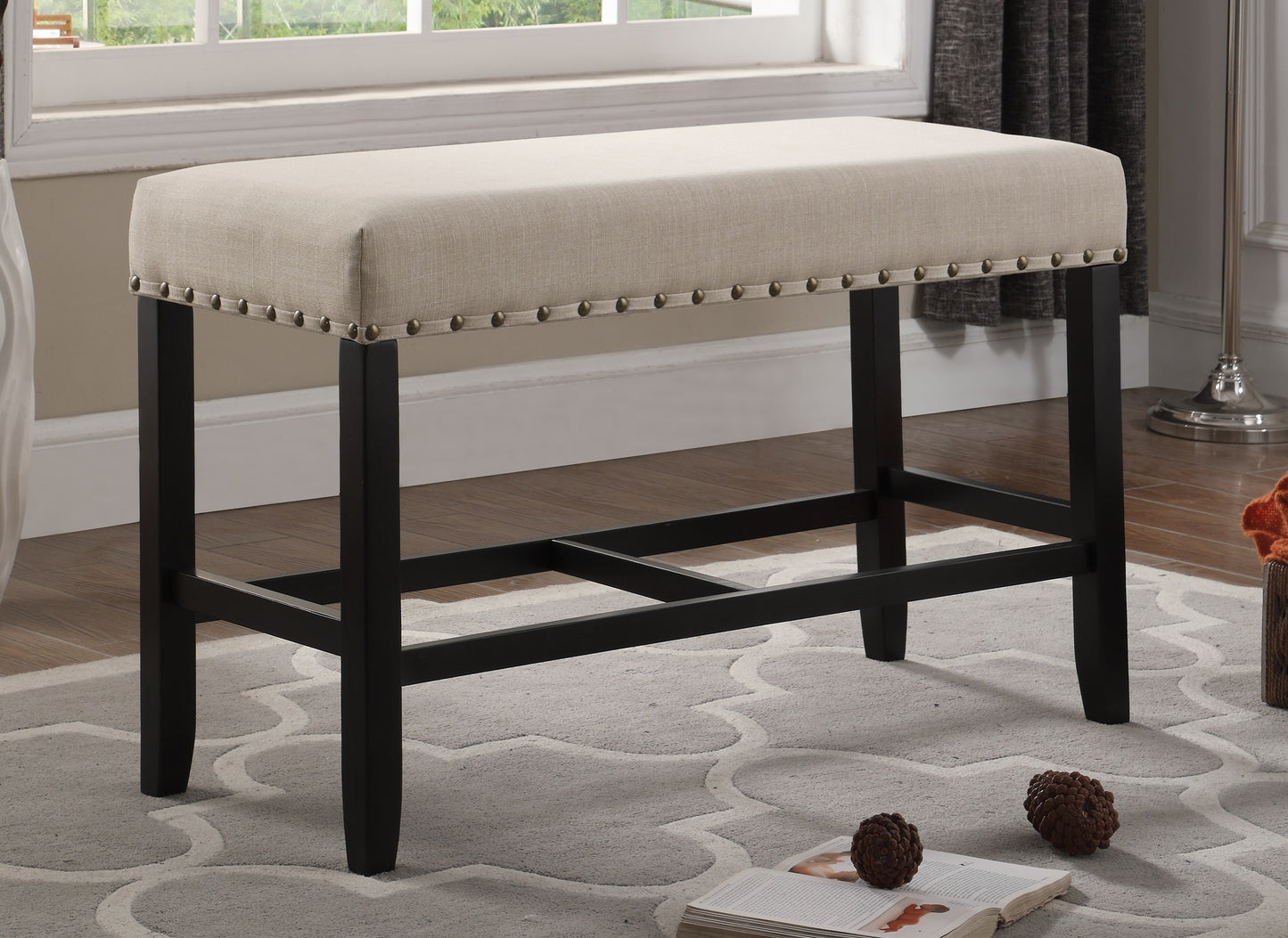 Beige upholstered bar stool with nailhead trim and dark wood legs