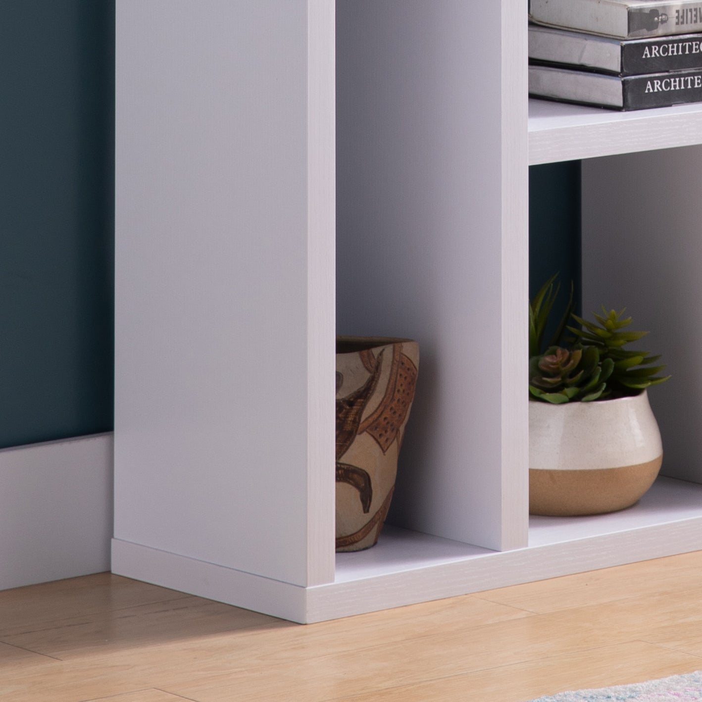 White modern bookshelf with decorative vase and succulent