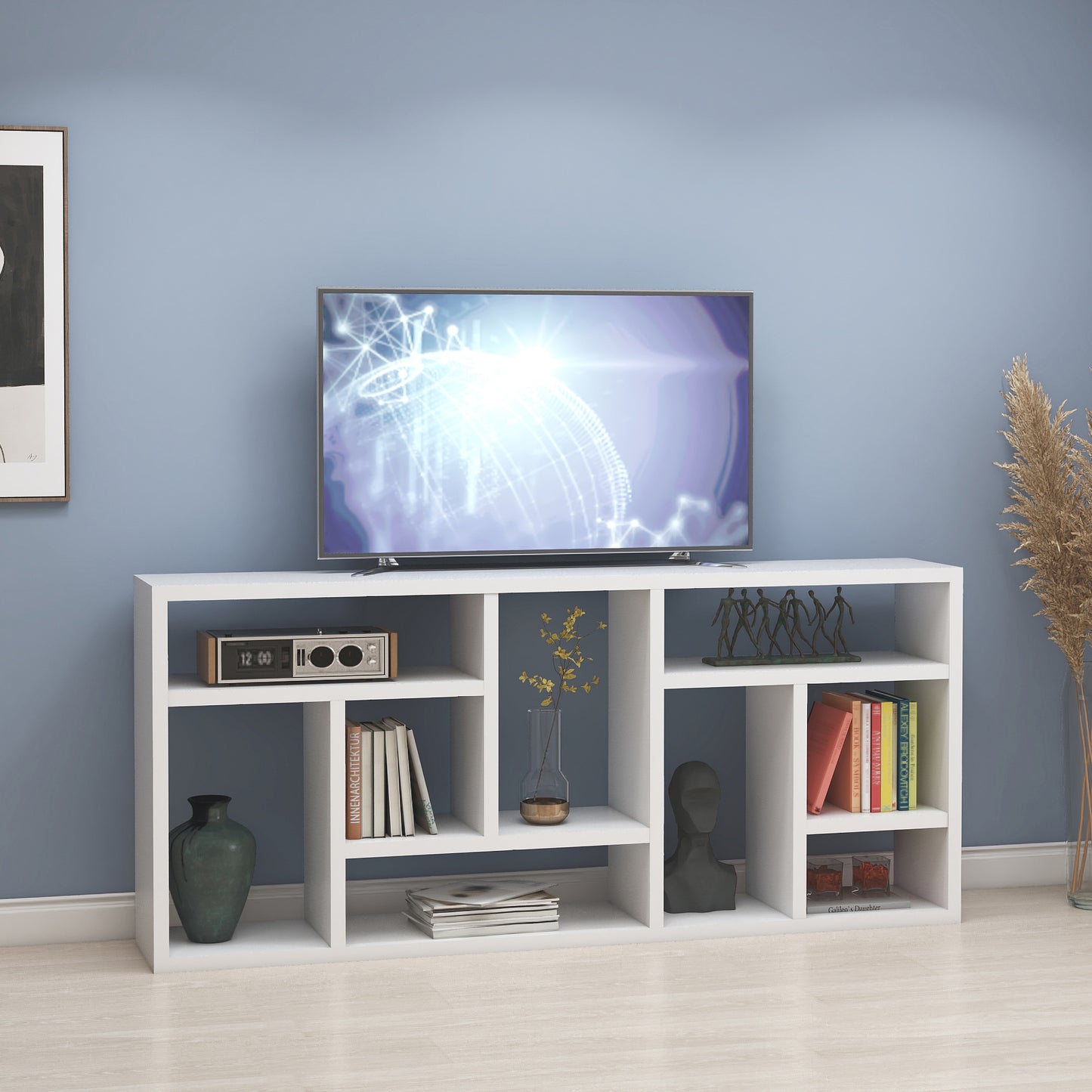 White modern media console with open shelves displaying a TV and decor