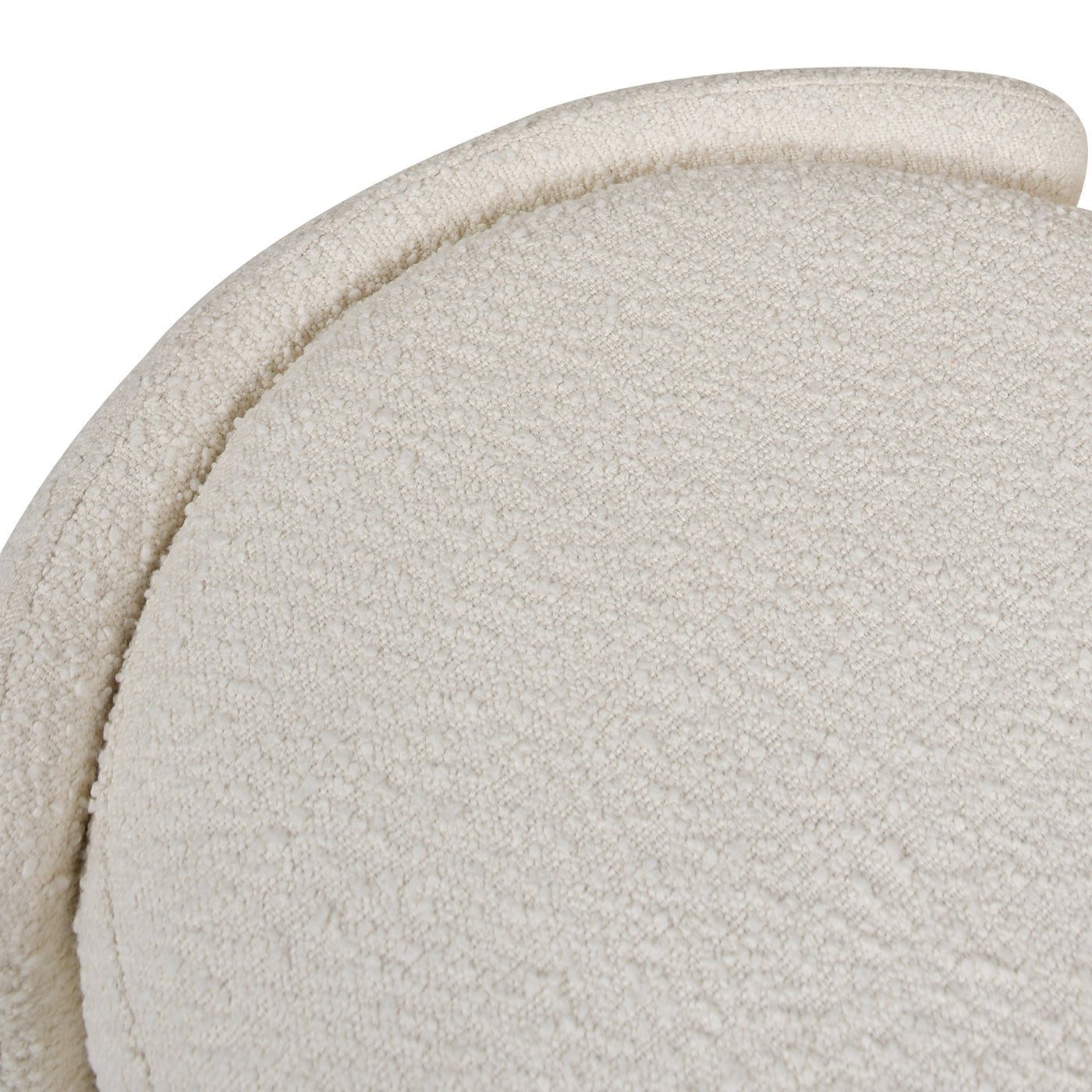 Closeup of textured cream boucle fabric on a curved accent chair