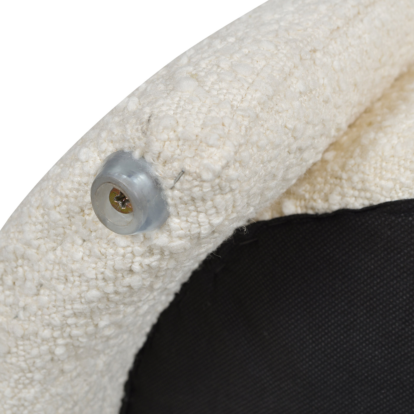 Cream boucle armchair leg with clear protective foot and visible screw