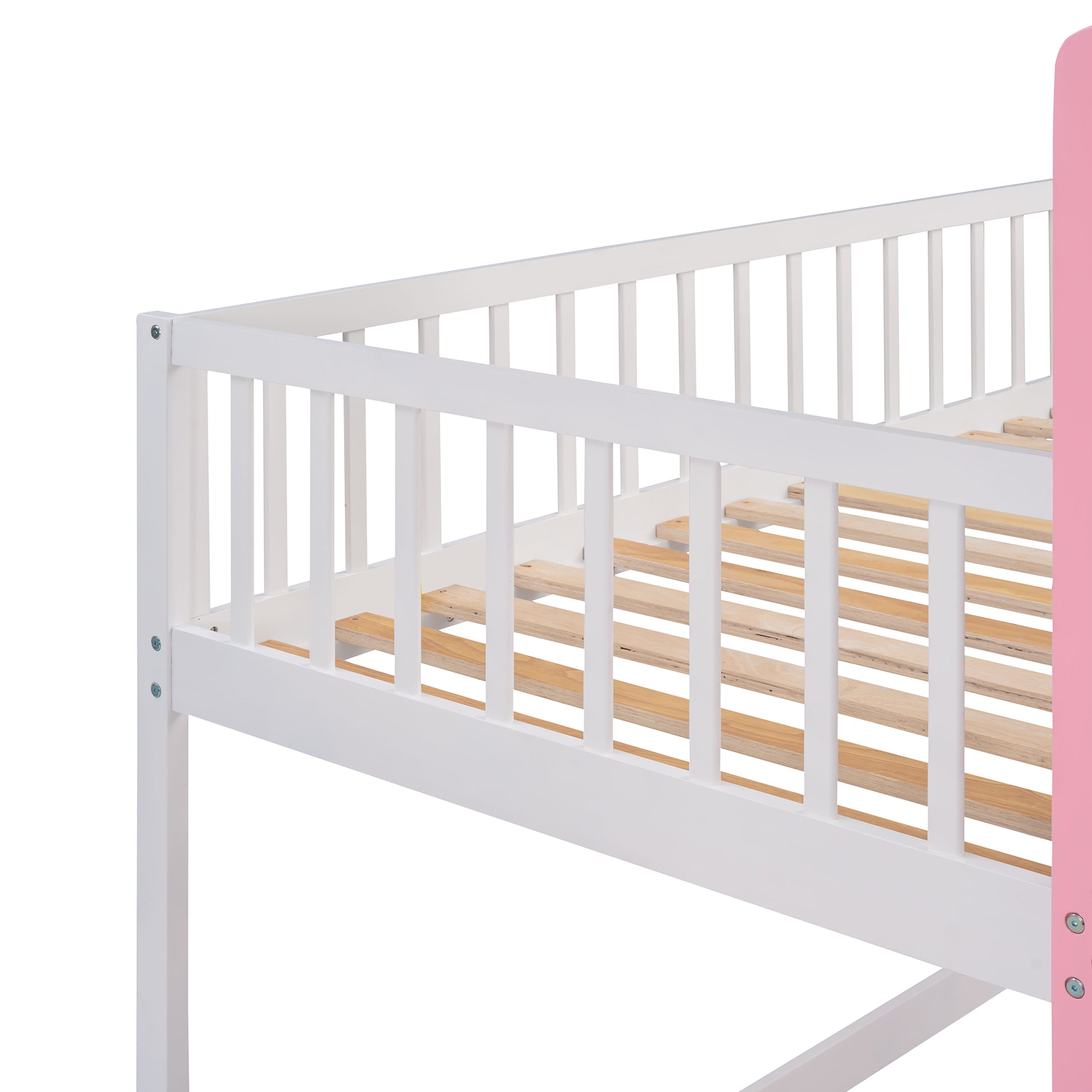 Closeup of white wooden bunk bed railing and slatted base with pink side panel