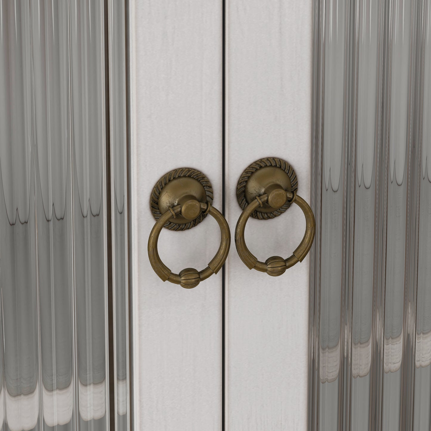 Antique brass ring pulls on white cabinet doors with ribbed glass panels