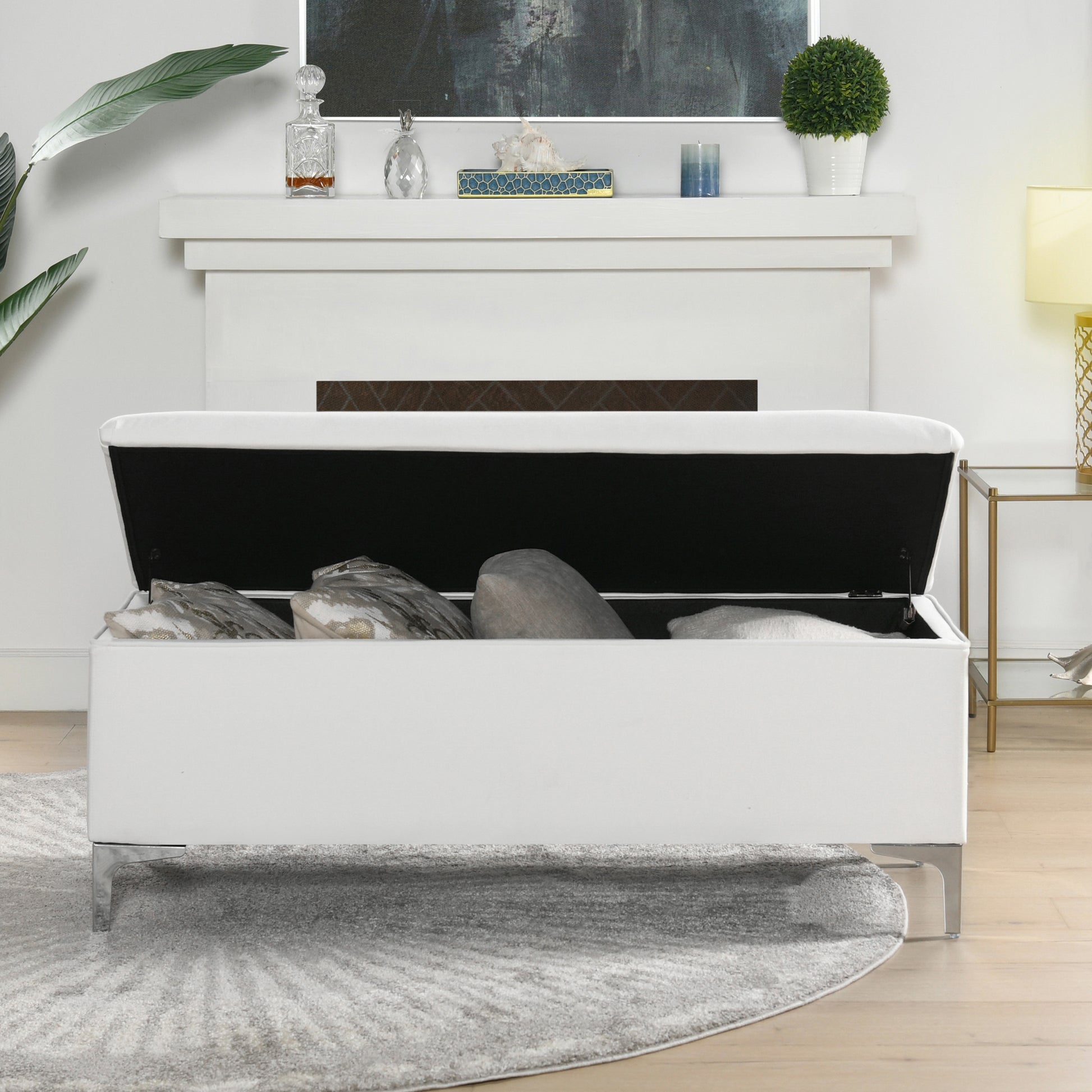 White upholstered storage bench with open lid revealing pillows