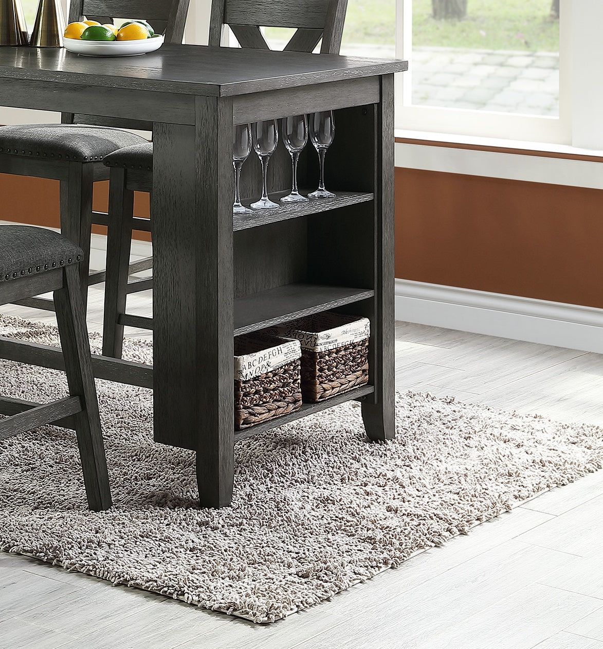 Dark grey counterheight table with builtin wine glass holder and woven baskets