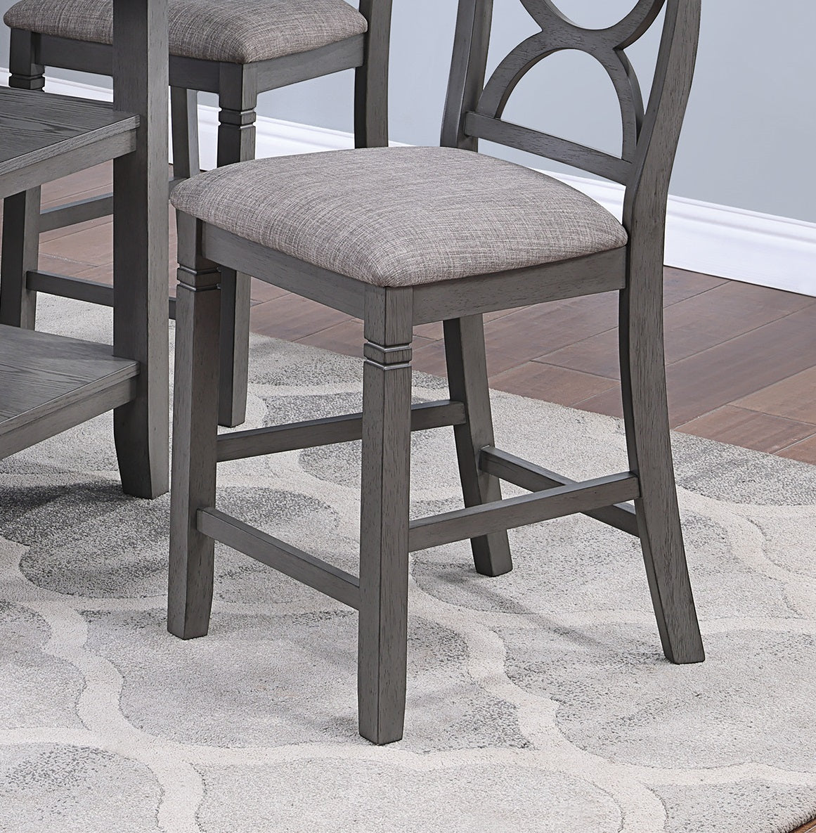 Grey upholstered bar stool with wood frame and cross back detail